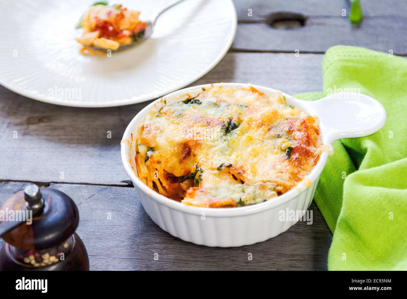 Baked Rigatoni with spinach in tomato sauce Stock Photo
