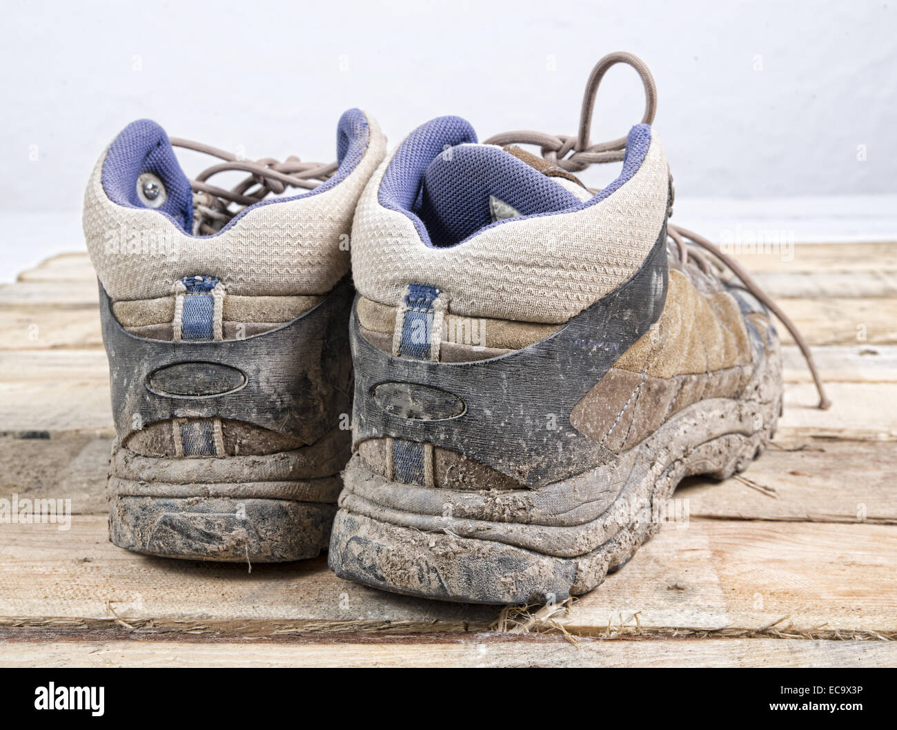 hiking shoes with mud laid on wood Stock Photo Alamy