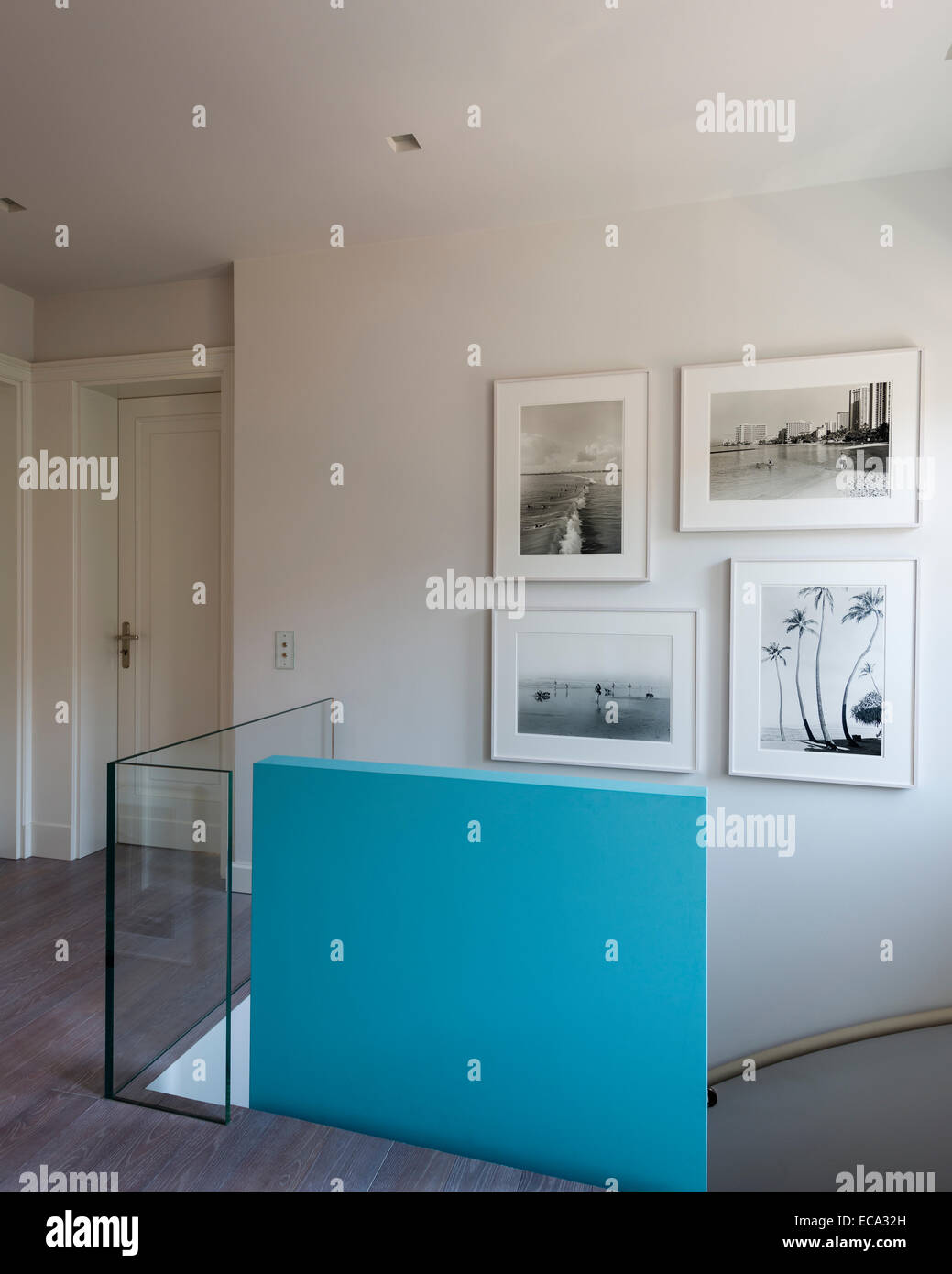 Aqua painted poured-concrete wall on landing with collection of Henry Wessel photographs Stock Photo