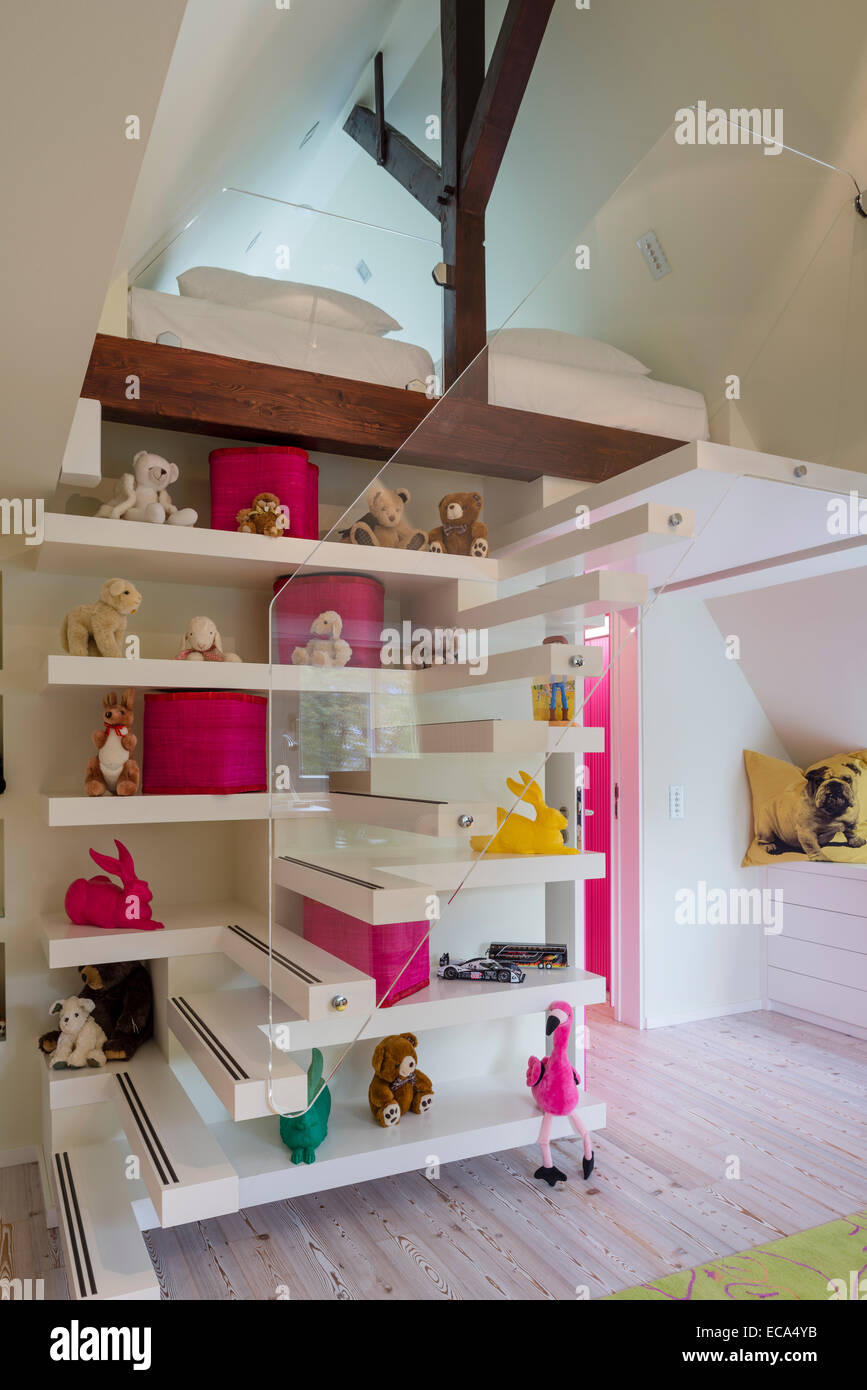 Collection of teddy bears and hares by Ottmar Hörl on open shelving tucked into floating stairs leading to mezzanine Stock Photo