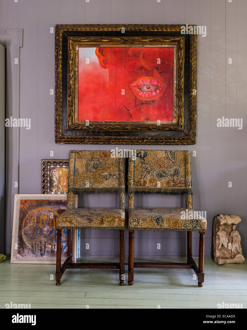 Pair of tapestry chairs underneath a Salle Werner Vaughn painting with antique frame Stock Photo