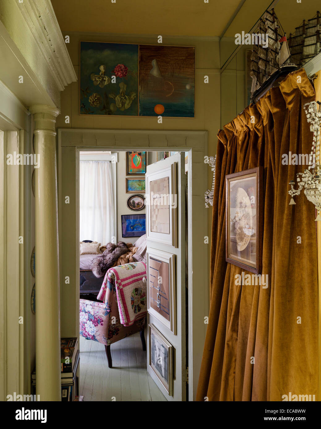 View down corridor with ochre velvet curtain into bedroom Stock Photo