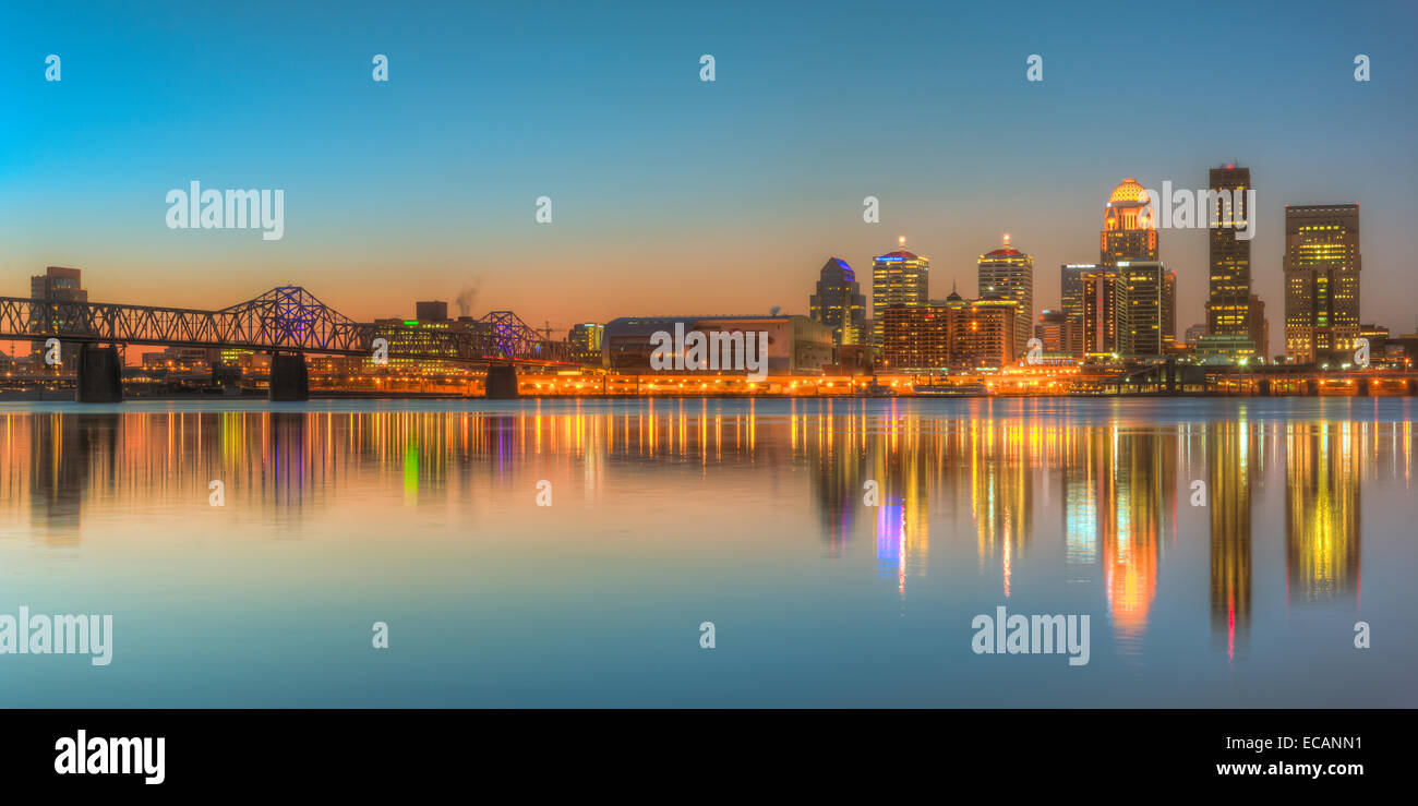 The skyline of Louisville, Kentucky, including the Second Street Bridge, reflects off the Ohio River shortly before sunrise. Stock Photo
