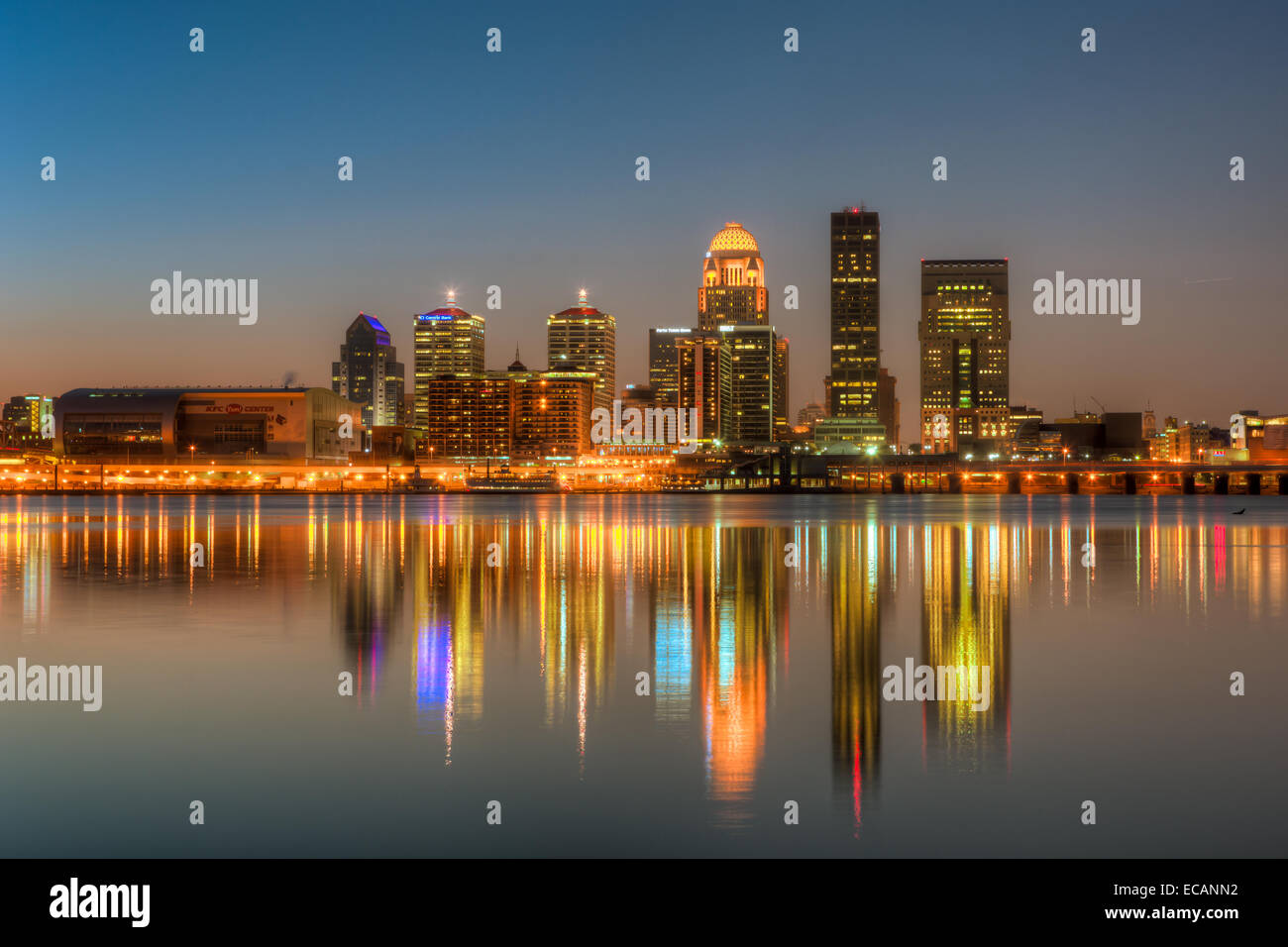 The illuminated skyline of Louisville, Kentucky reflects off Ohio River under a clear sky shortly before sunrise. Stock Photo