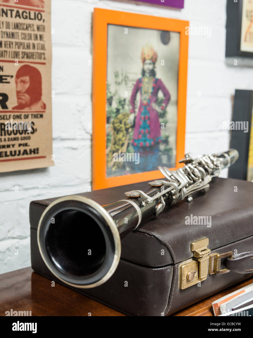 Clarinet on leather case. An eclectic mix of art hangs on the wall in the background Stock Photo