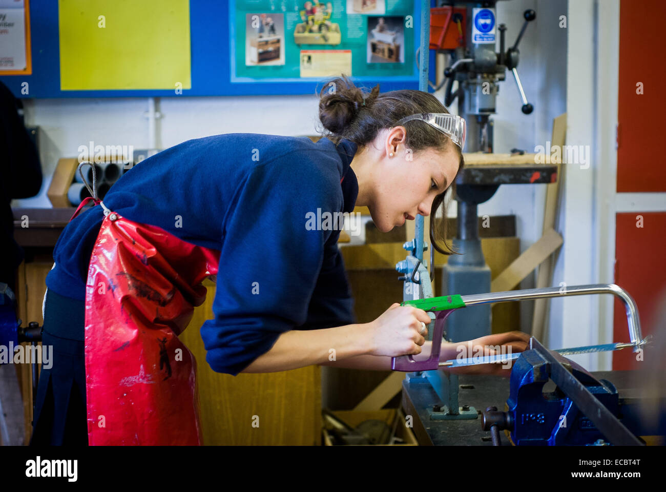 School girl  aged 15 with a hacksaw in an STEM engineering class, UK Stock Photo