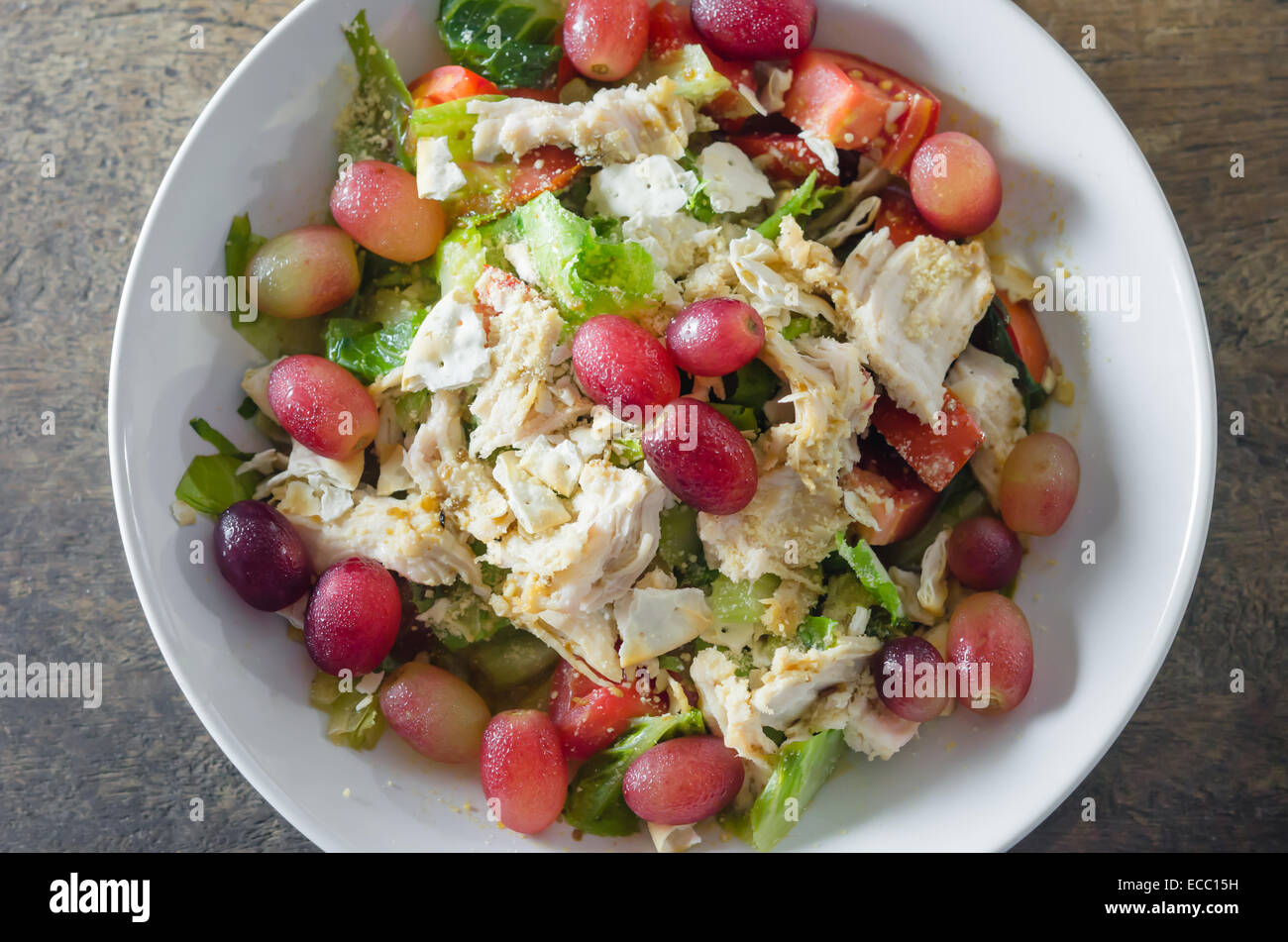 Mix salad with grapes and chicken on white dish Stock Photo