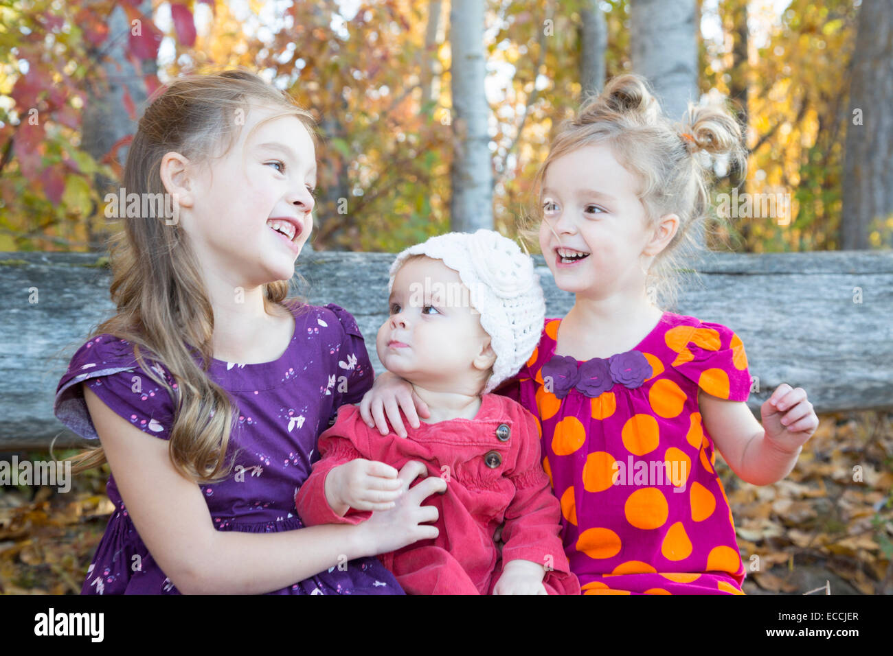 Three young sisters laugh while posing during a family photo in Kalispell, Montana. Stock Photo