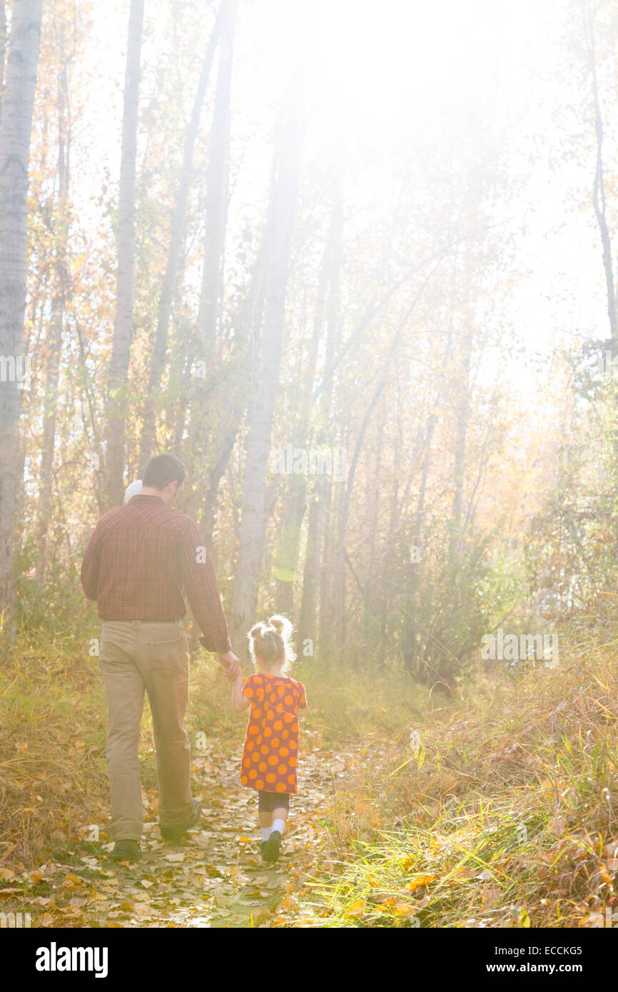 A father walks with his two daughters during a fall family portrait session in Kalispell, Montana. Stock Photo
