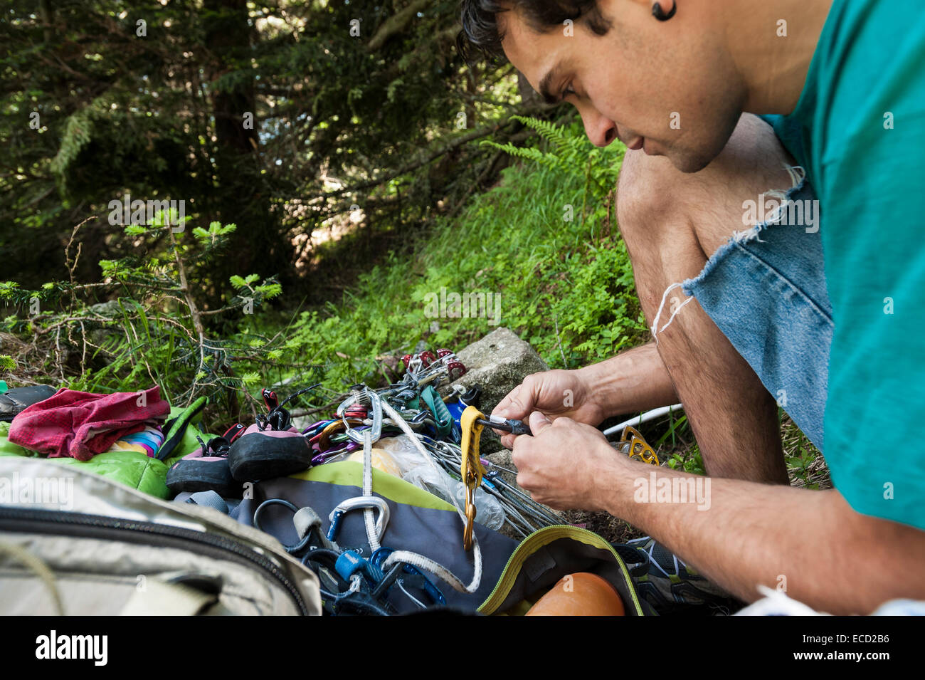 Young man checking the gear before a crack climbing session in Esigo crag, Ossola, Italy. Stock Photo