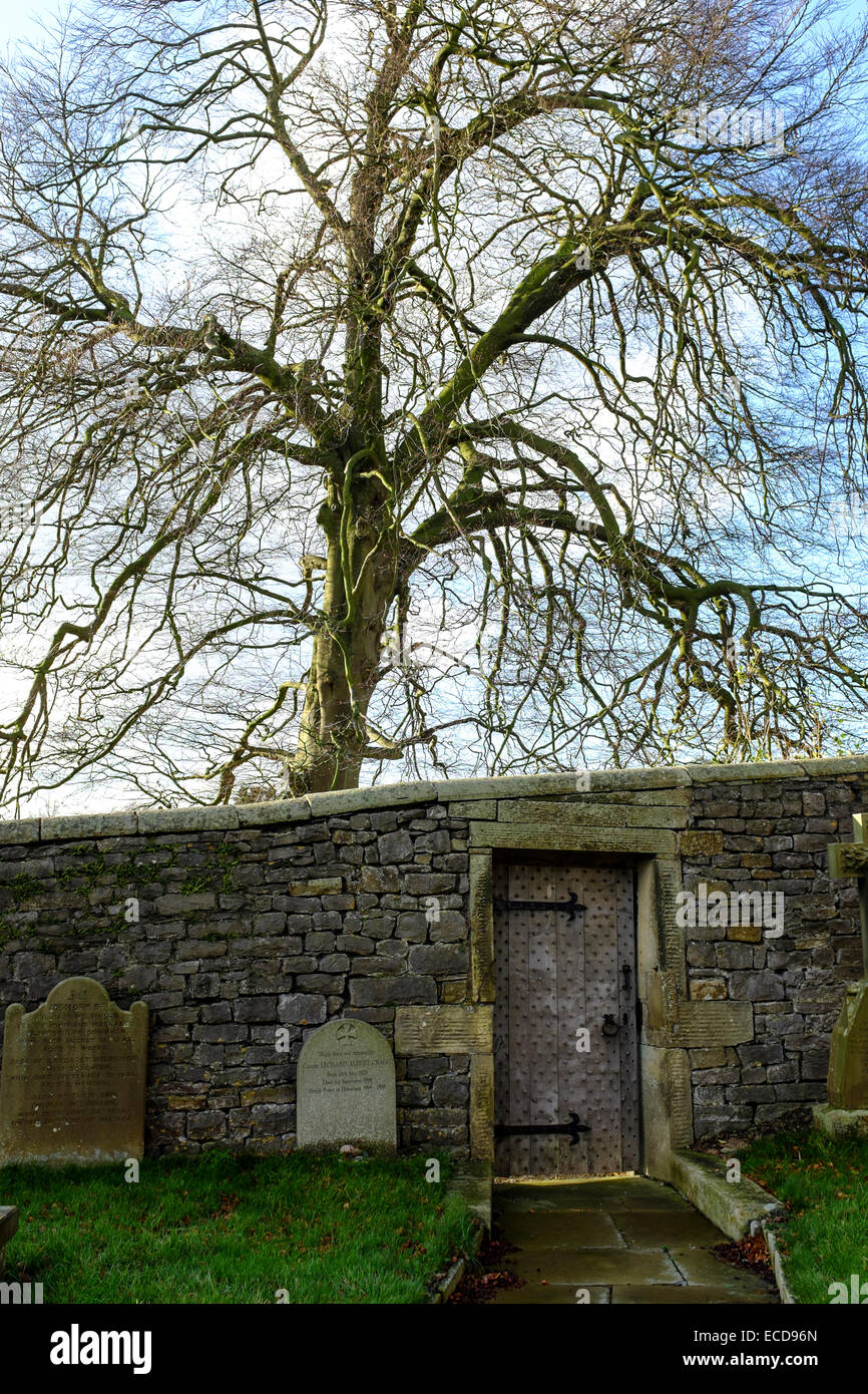 A heavy wooden door with door studs in a churchyard stone wall Stock ...
