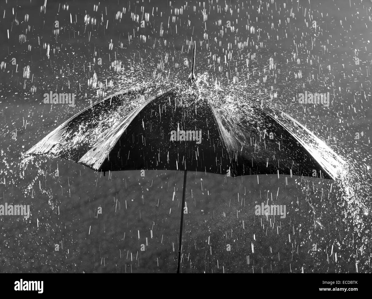 Black and white photo of umbrella in heavy rain Stock Photo