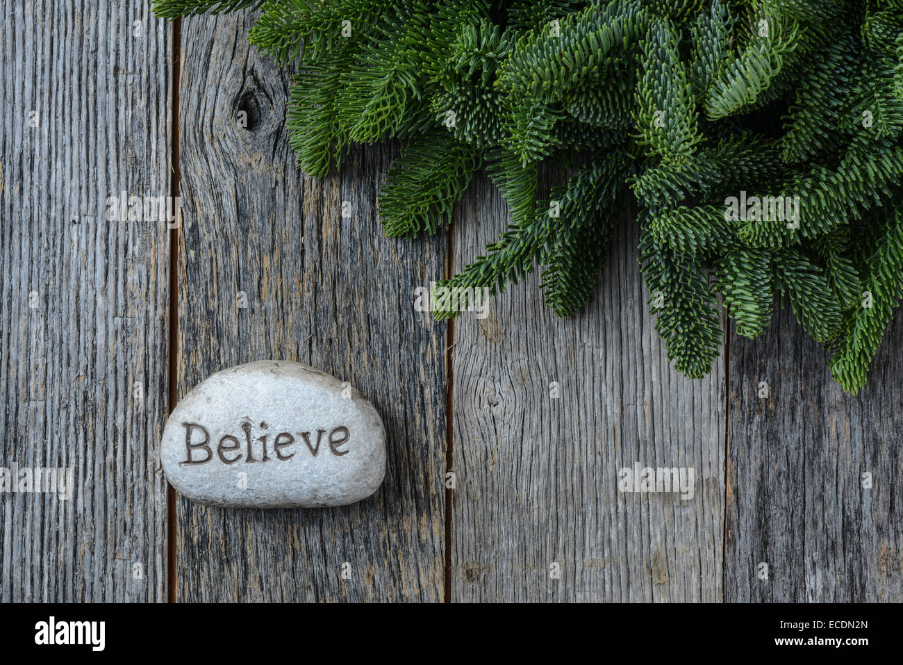Believe in Christmas with Pine Needles on Rustic Wood Background Stock Photo