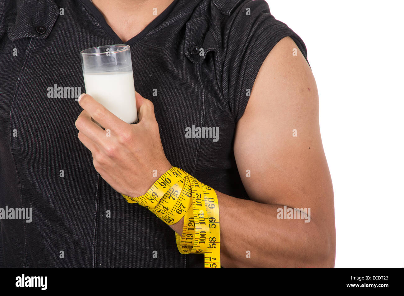 athletic young man's arm wrapped around measuring tape holding glass of