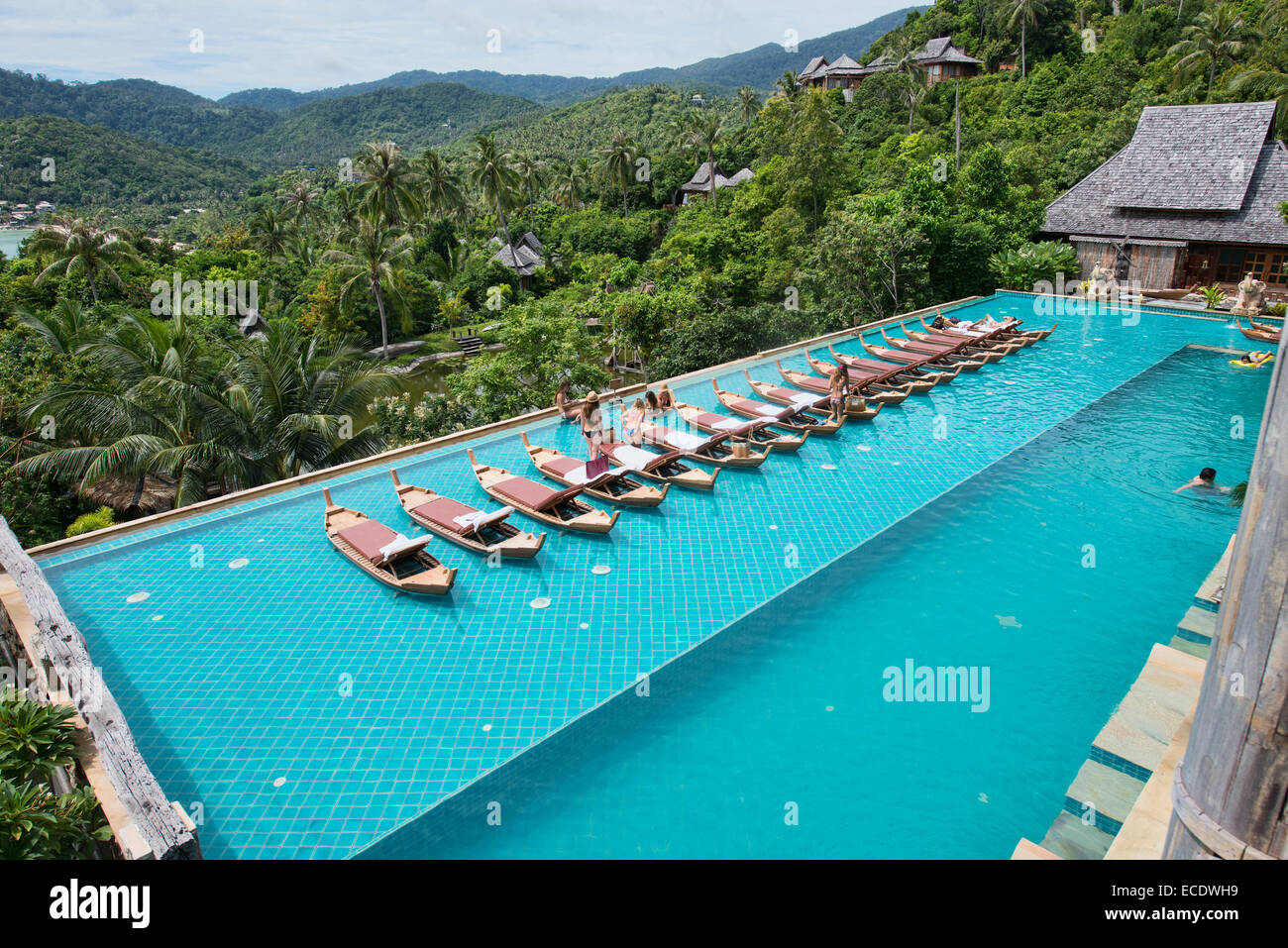 Relaxing on floating sunbeds in a luxury pool on Koh Phangan, Thailand Stock Photo