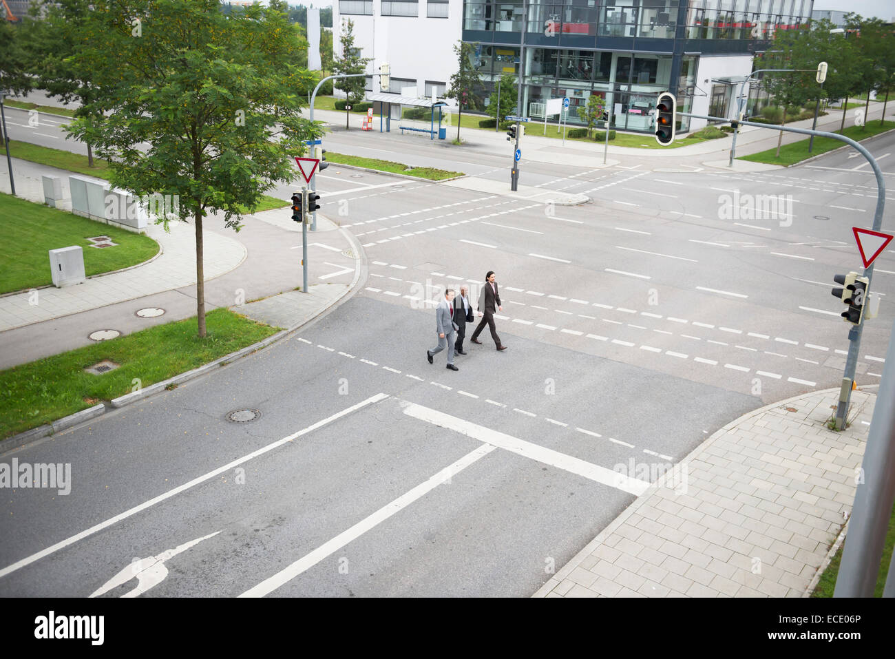 From above three businessmen crossing road team Stock Photo