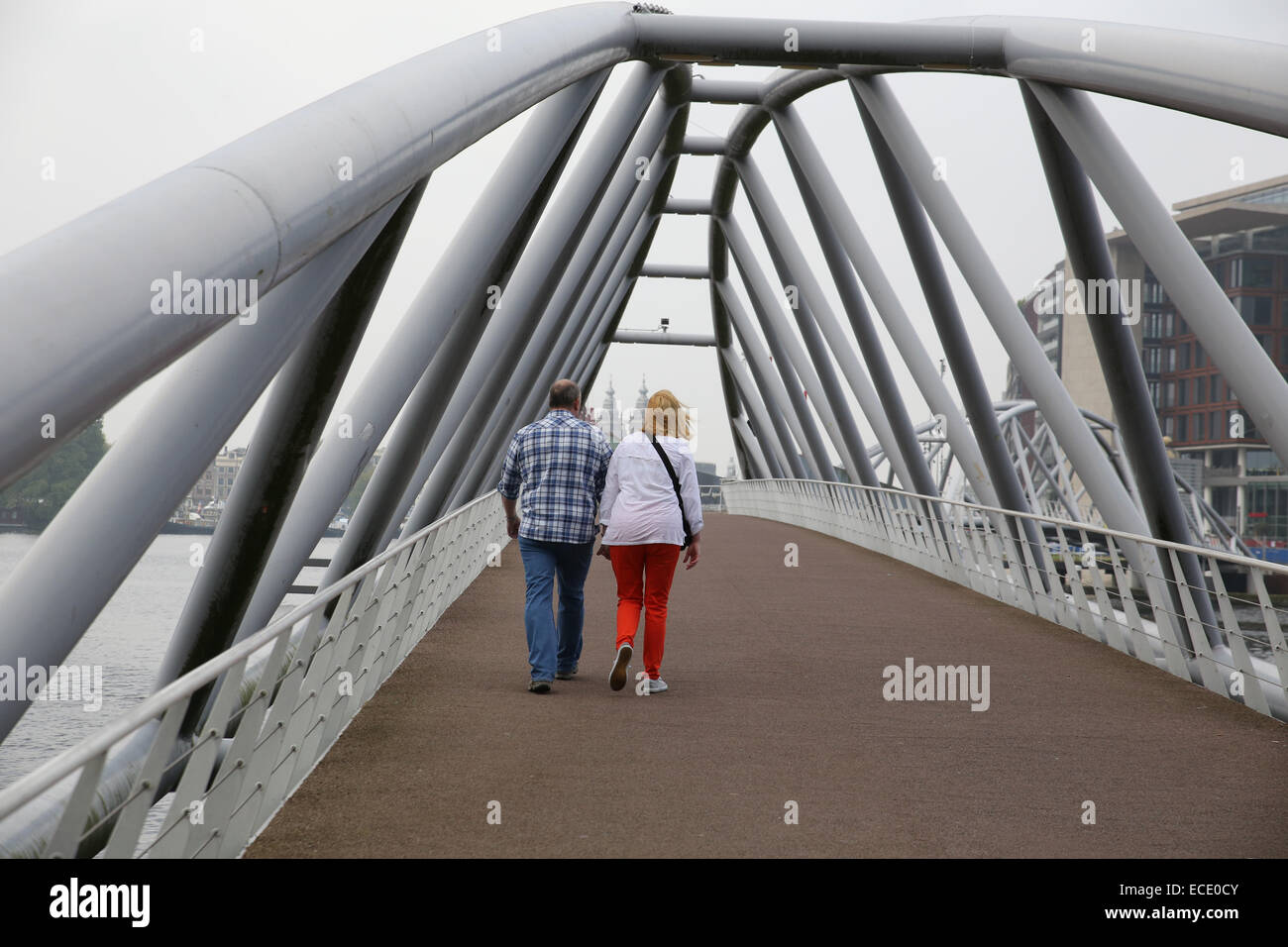 middle age couple holding hands walking bridge Europe Stock Photo