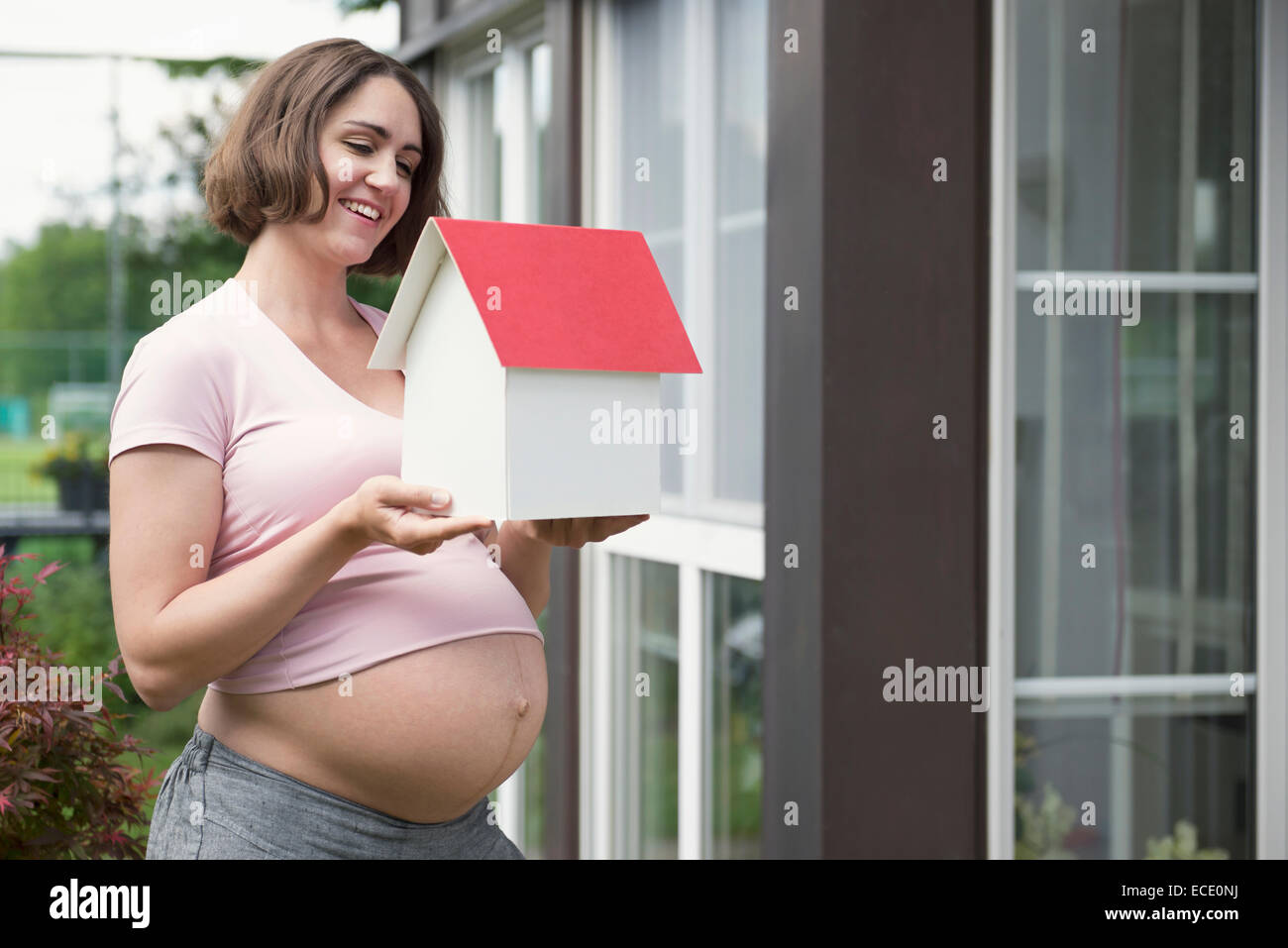 Woman holding model house positive future Stock Photo