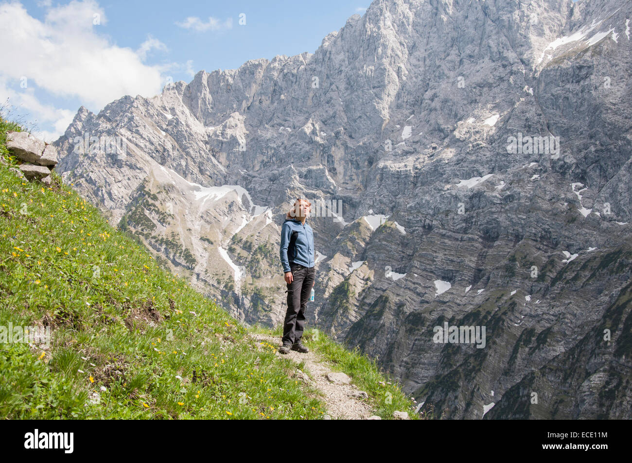 Woman alone mountain path trekking summer Stock Photo