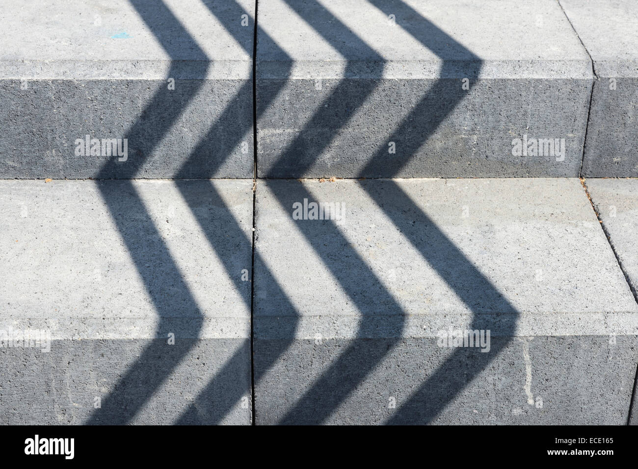 Shadows in straight lines on a gray stone staircase Stock Photo