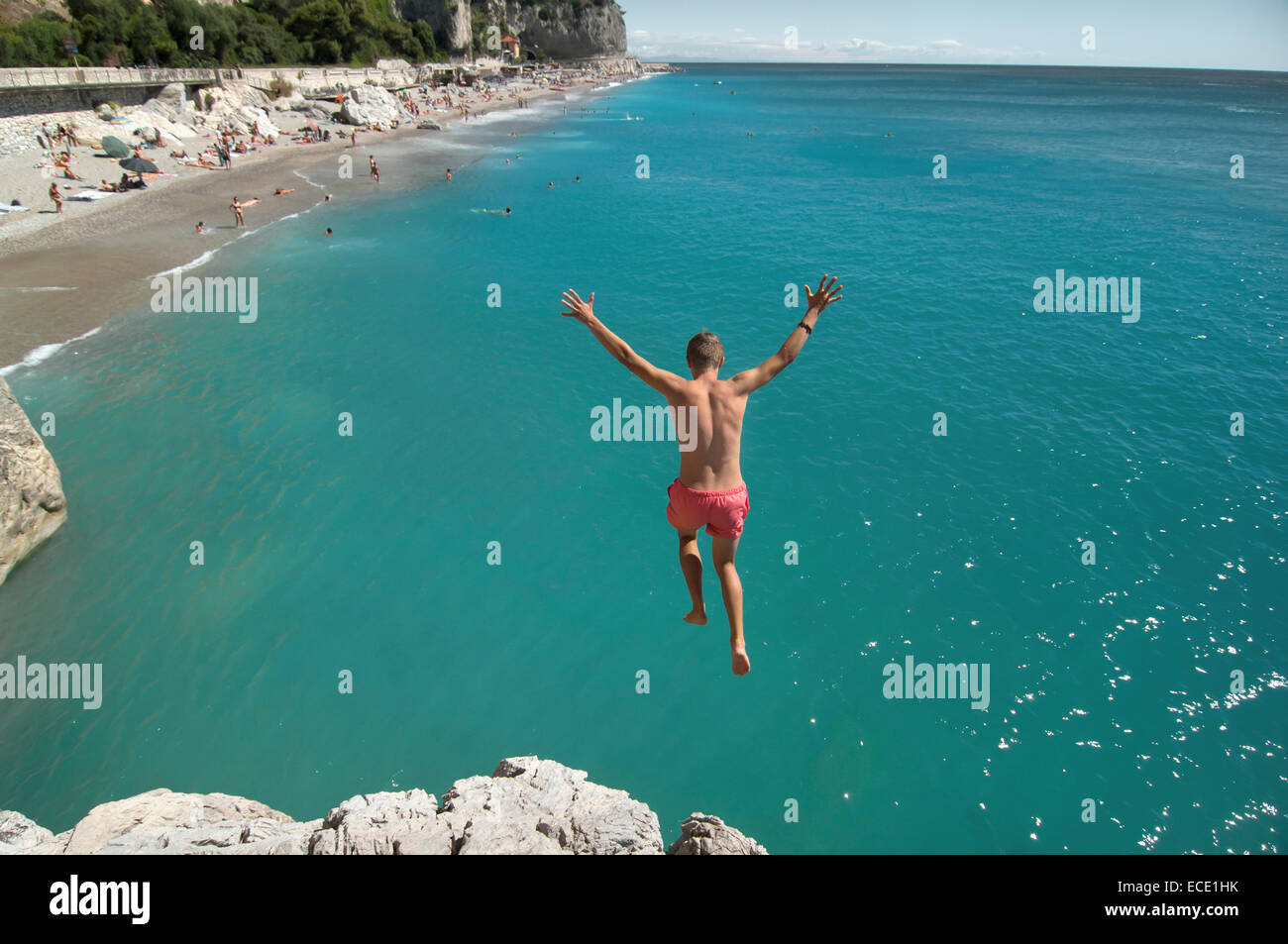 Boy holiday jump water ocean risk teenager Stock Photo