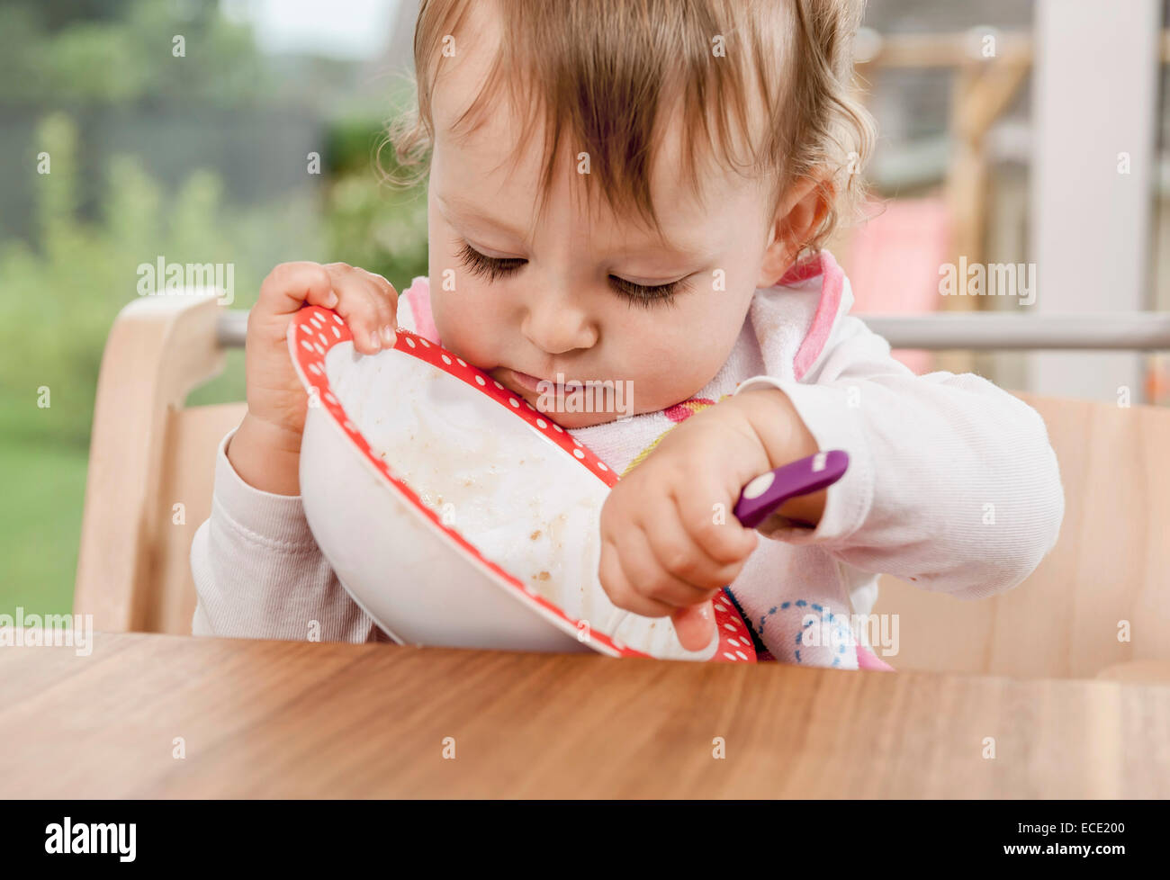 Hungry baby girl 1 year old bowl eating Stock Photo