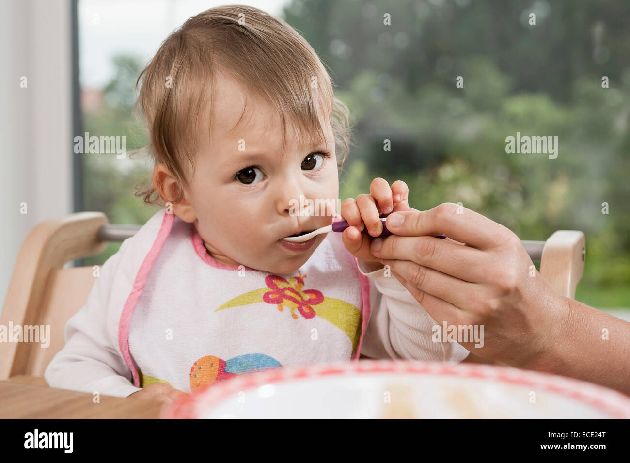 Portrait 1 year old baby girl spoon eating Stock Photo