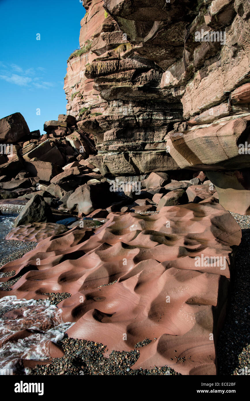 Unusual red sandstone formation on the shingle beach at Fleswick Bay near St Bees in Cumbria in North West England Stock Photo