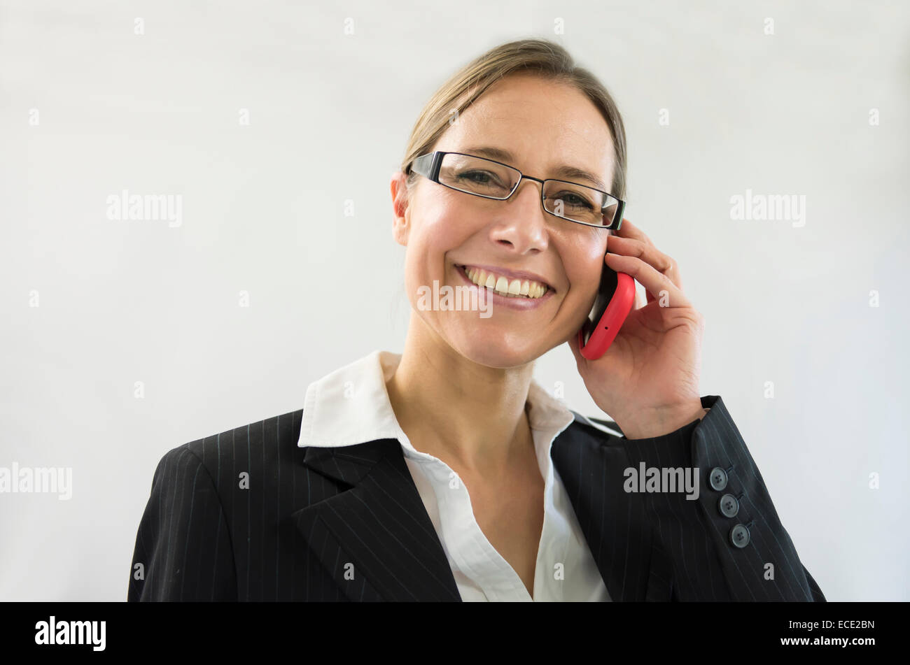 businesswoman in black suit talking on smart phone, smiling Stock Photo