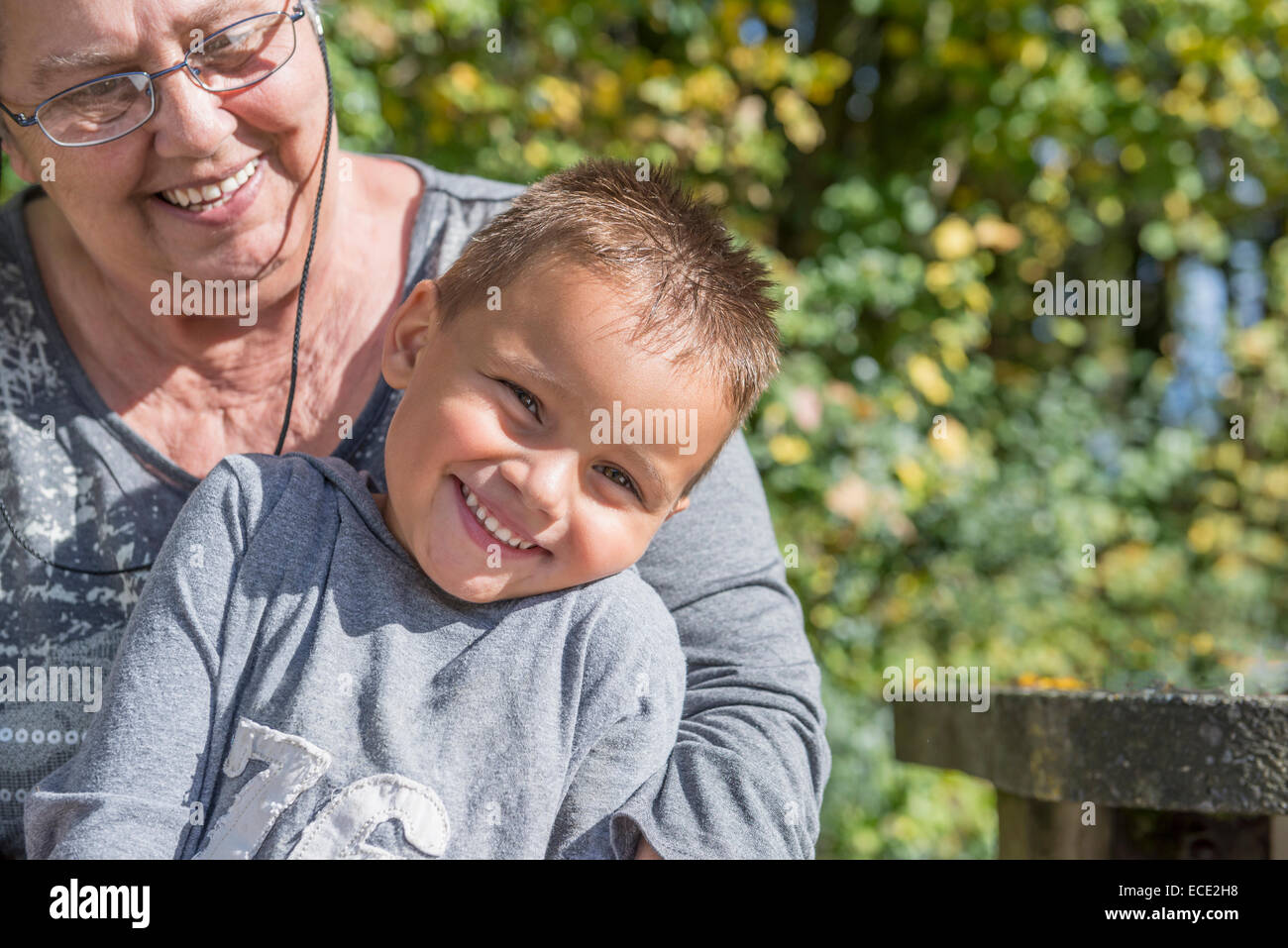 Small young boy sitting on grandmothers knee Stock Photo