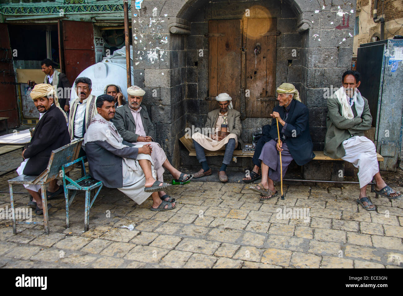 Men sitting in front of a house in the old city, Sana'a, Yemen Stock Photo