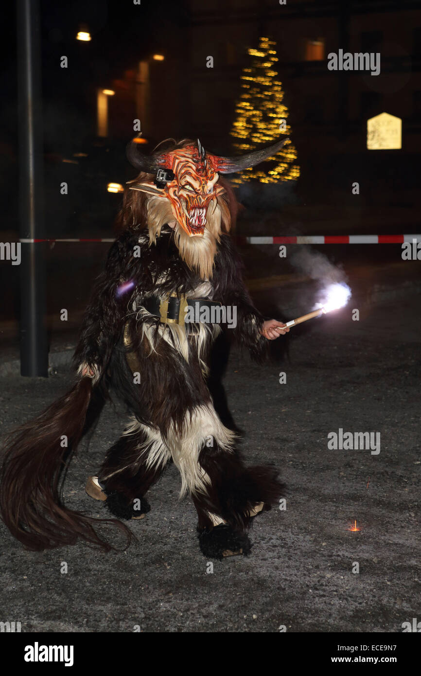 A Krampus figure carries a torch and participates in a Krampus run in