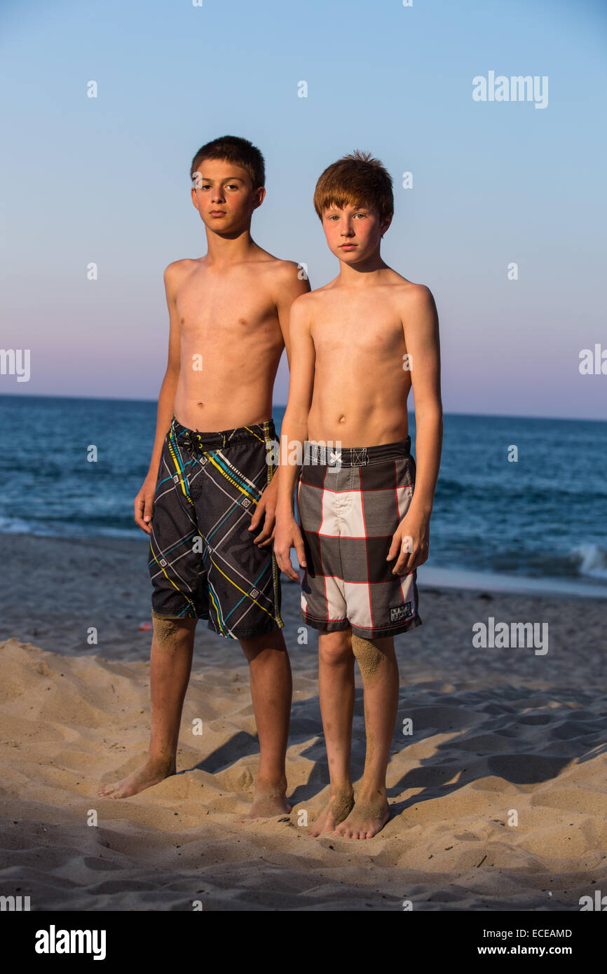 Two Boys Standing On Beach At Sunset Stock Photo Alamy