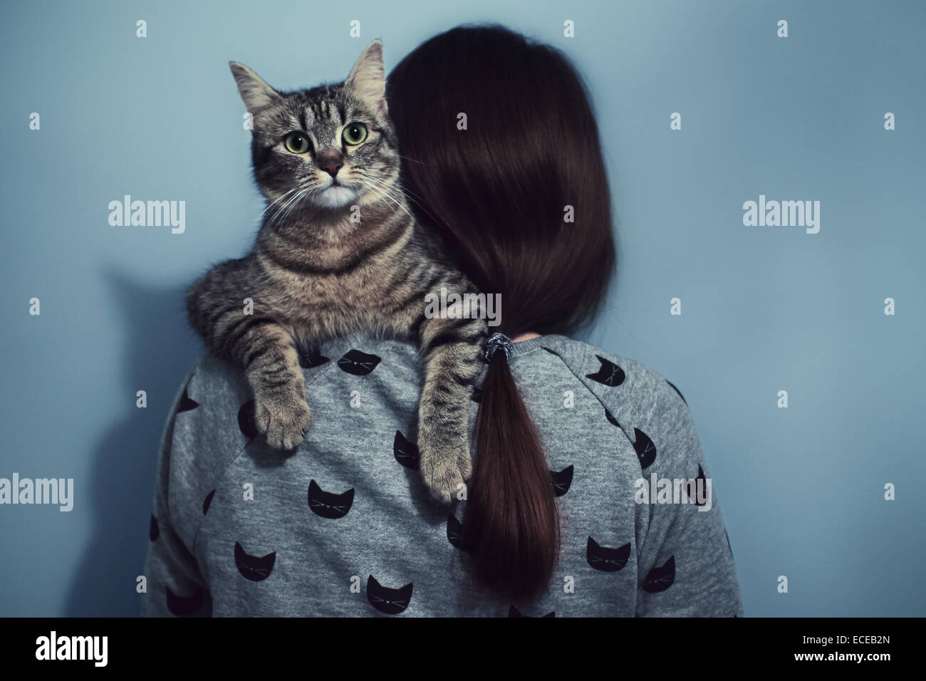 Woman holding cat over her shoulders Stock Photo