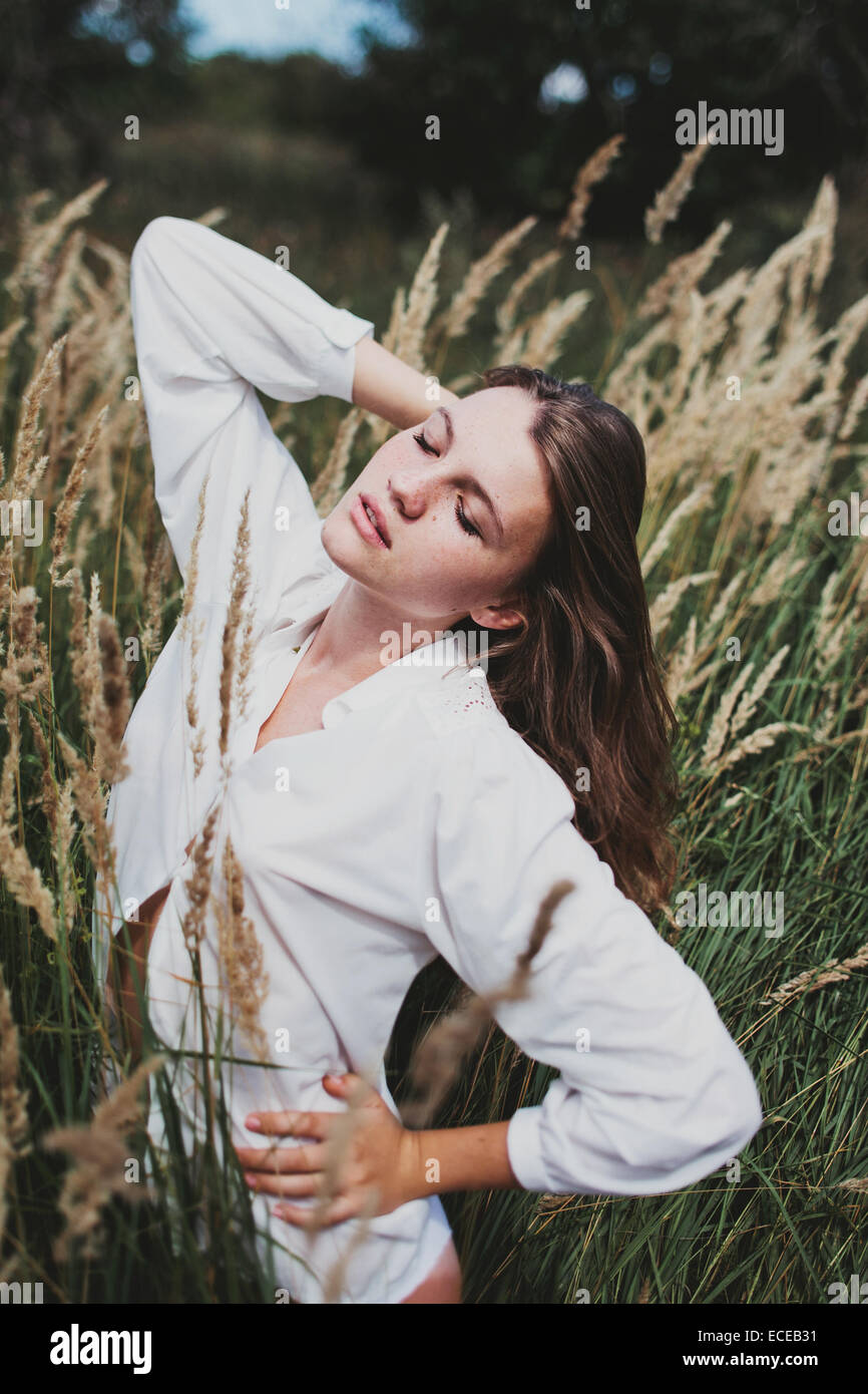 Girl standing in a meadow with her eyes closed Stock Photo - Alamy
