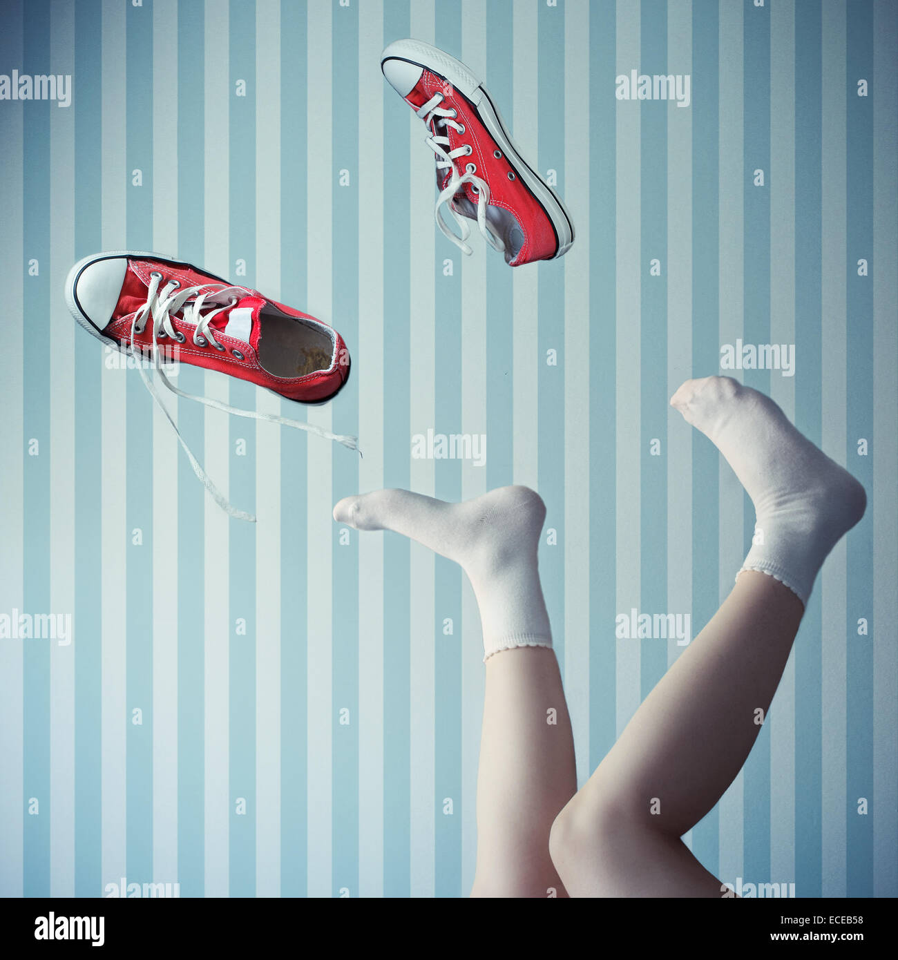 Woman with her legs in the air and trainers mid air Stock Photo
