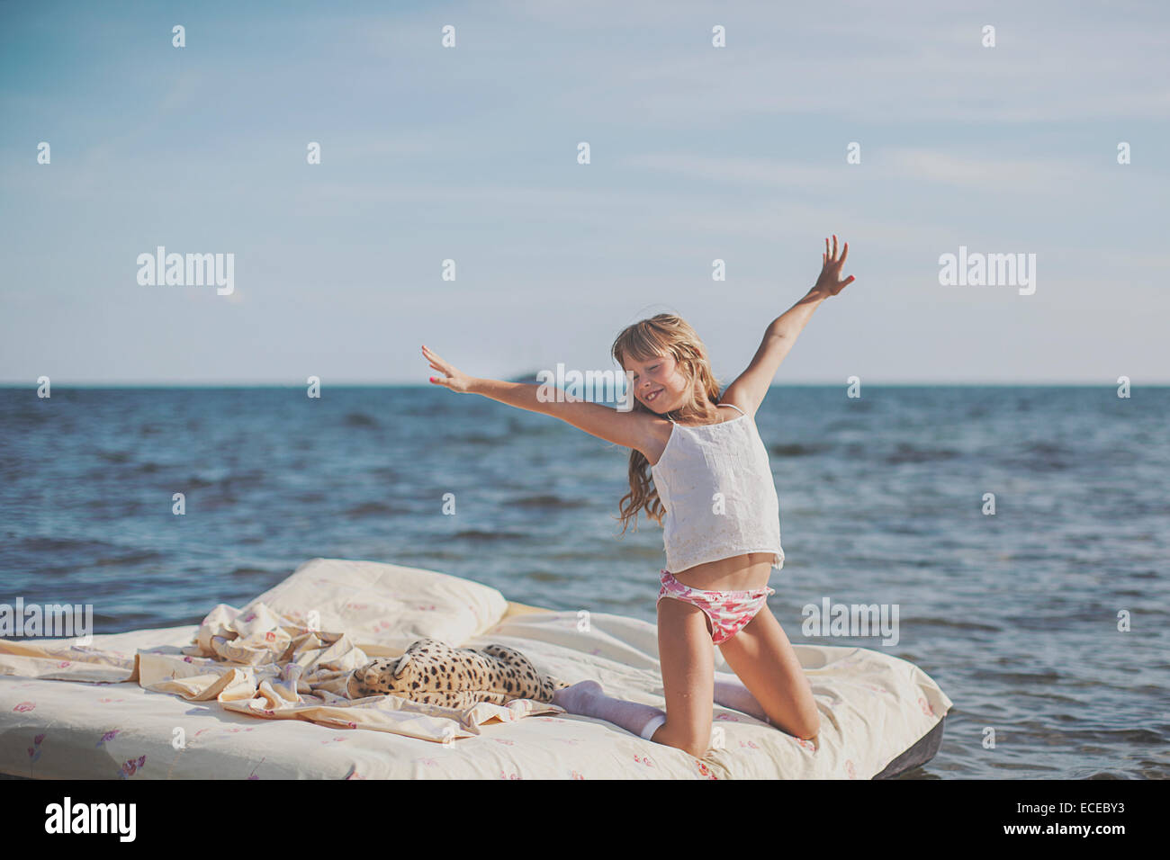 Young blonde haired child (8-9) on air bed at sea Stock Photo