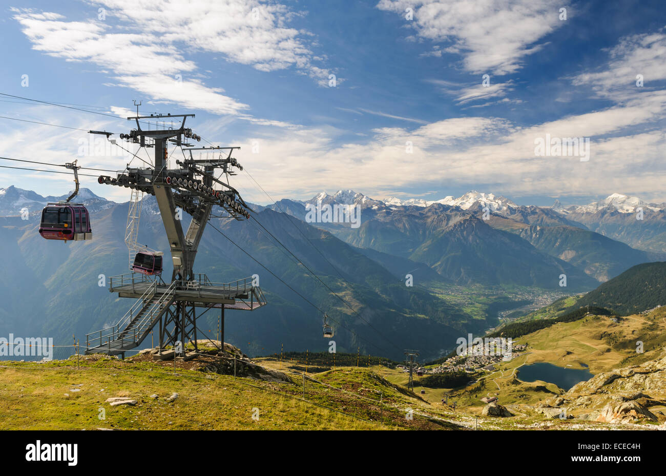 Switzerland, Valais, Betten, Bettmergrat, Overhead cable car passing by tower in mountains Stock Photo