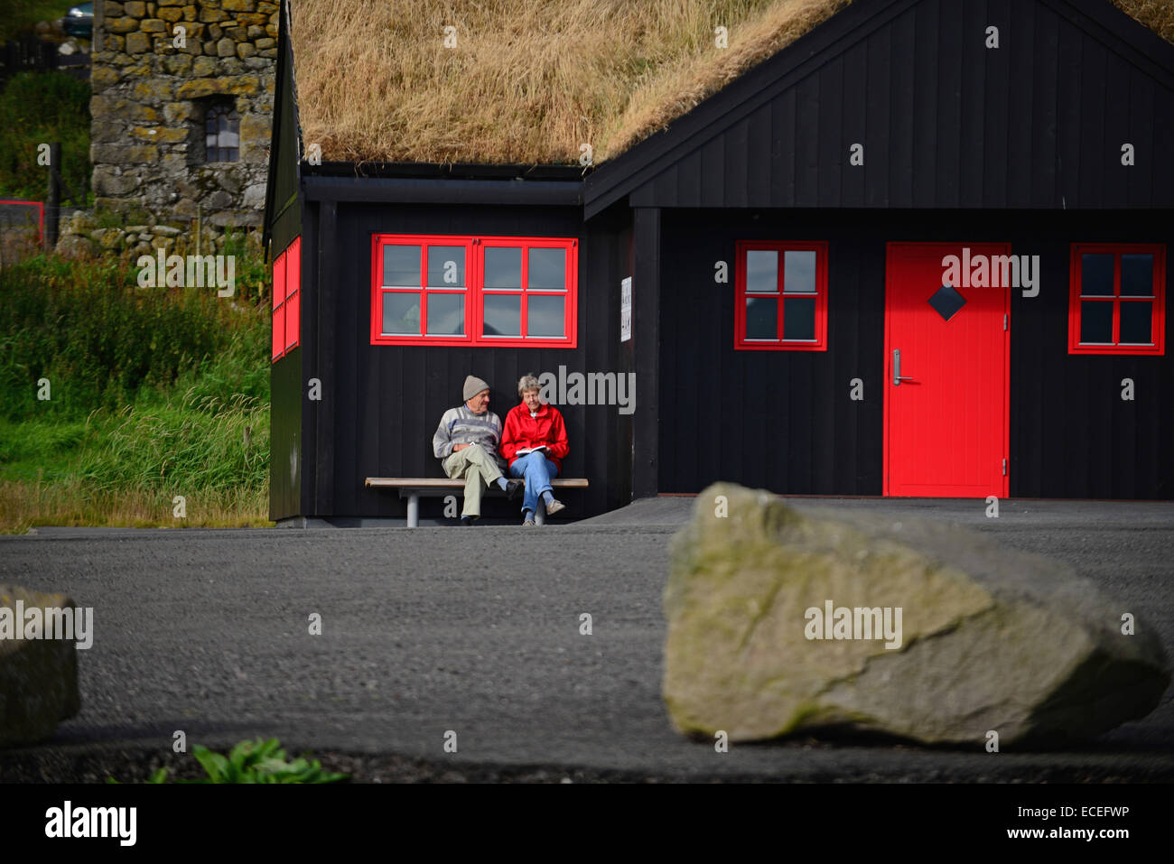 Elderly couple sitting on bench in Kirkjubøur, Faroe Islands Stock Photo