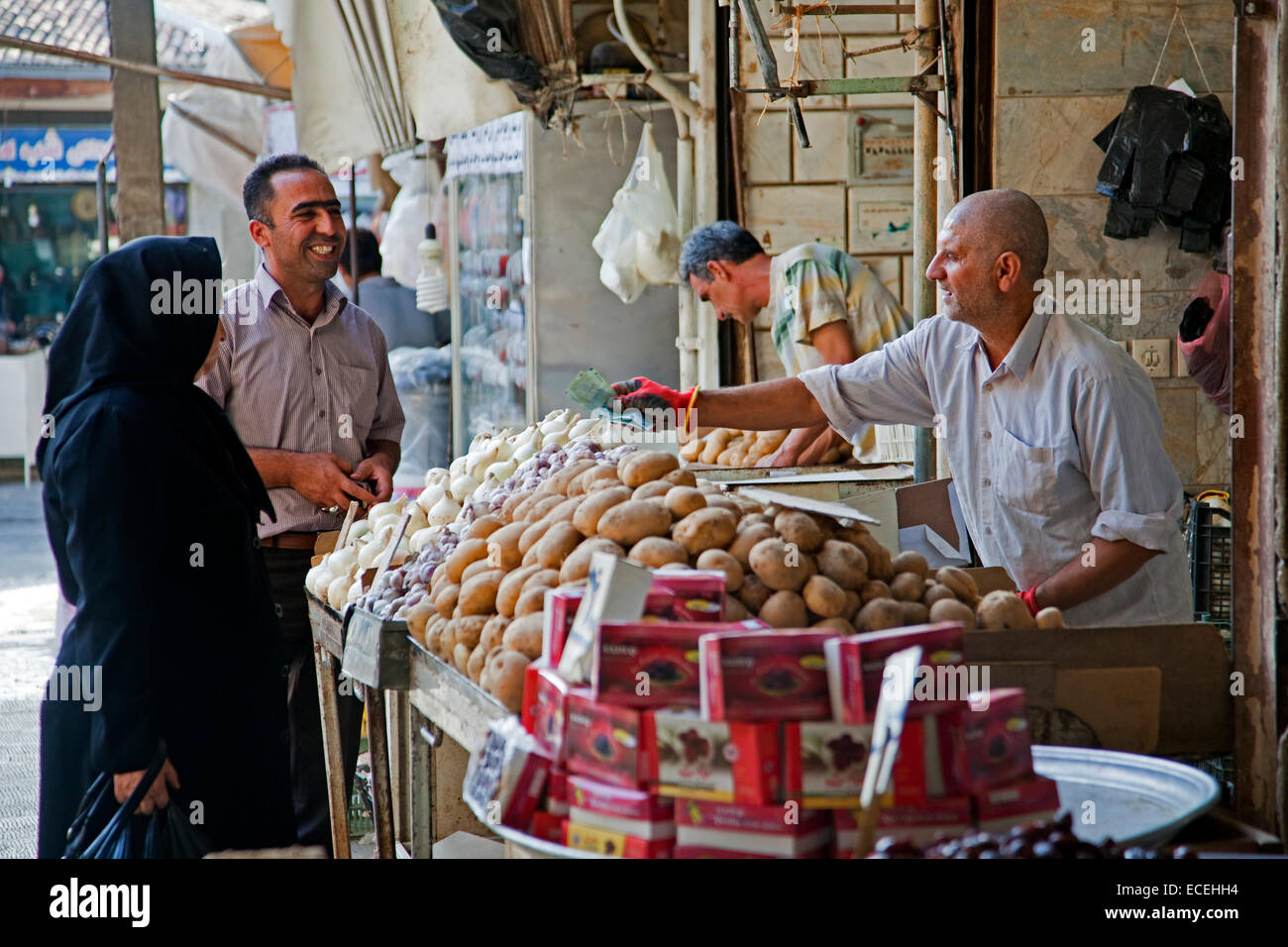 Iranian Muslim woman dressed in black buying food at vegetable market in the city Gorgan / Gurgan, Golestan Province, Iran Stock Photo