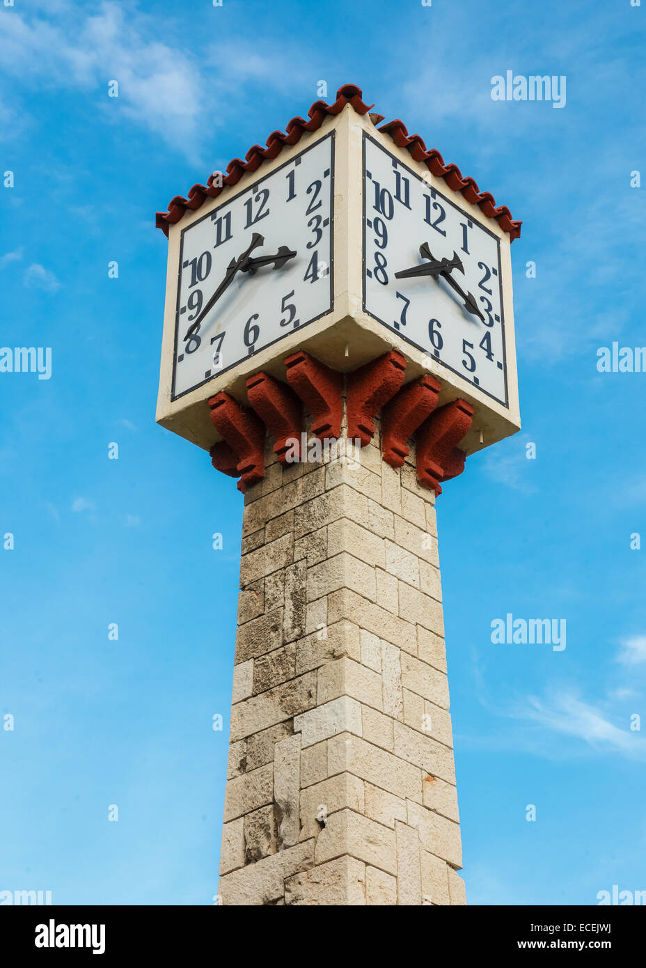 Old tower clock in Piraeus, Greece with blue sky as a background Stock Photo