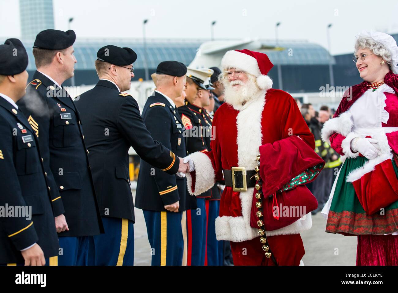 Mr. and Mrs. Santa Claus shake hands with military service members during a Snowball Express farewell ceremony at O'Hare International Airport December 11, 2014 in Chicago, IL.  Snowball Express is a nonprofit organization that organizes all-expenses-paid trip for children and spouses who have lost a fallen military family member. Stock Photo