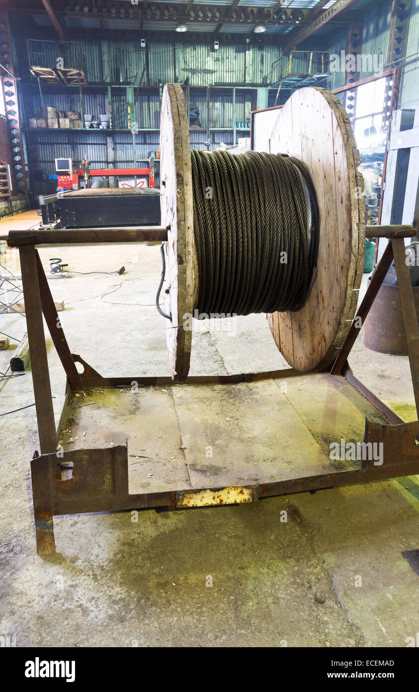industrial wooden reel with steel wire rope in mechanical workshop
