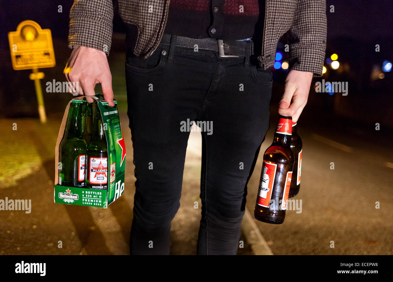 A teenager with alcohol on a UK street at night. Stock Photo