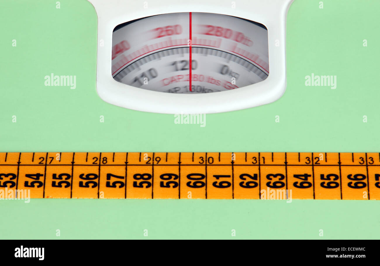 Bathroom scale with a measuring tape, weight loss concept. Stock Photo