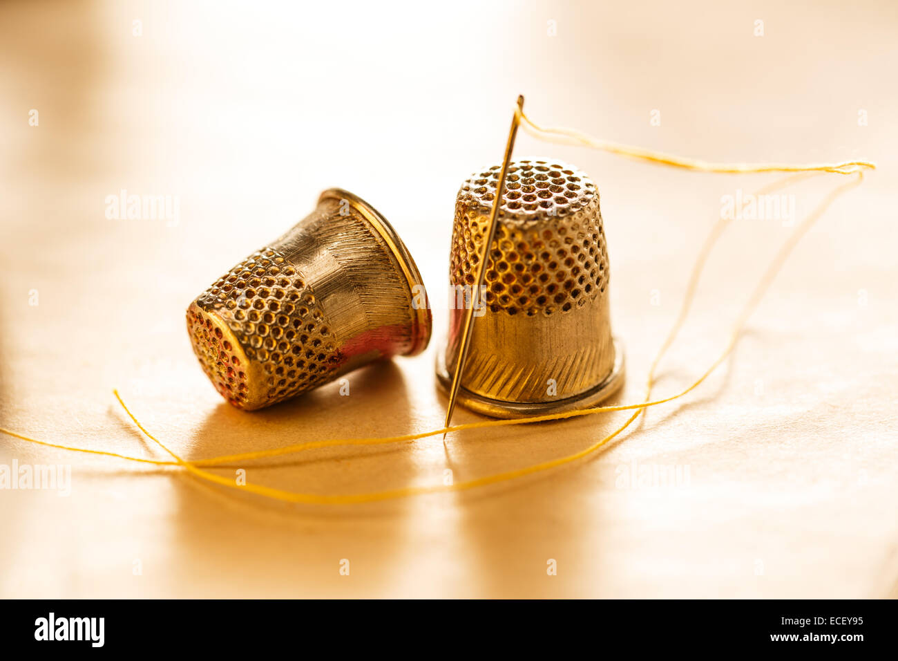 Two metal sewing thimbles and needle with thread Stock Photo Alamy