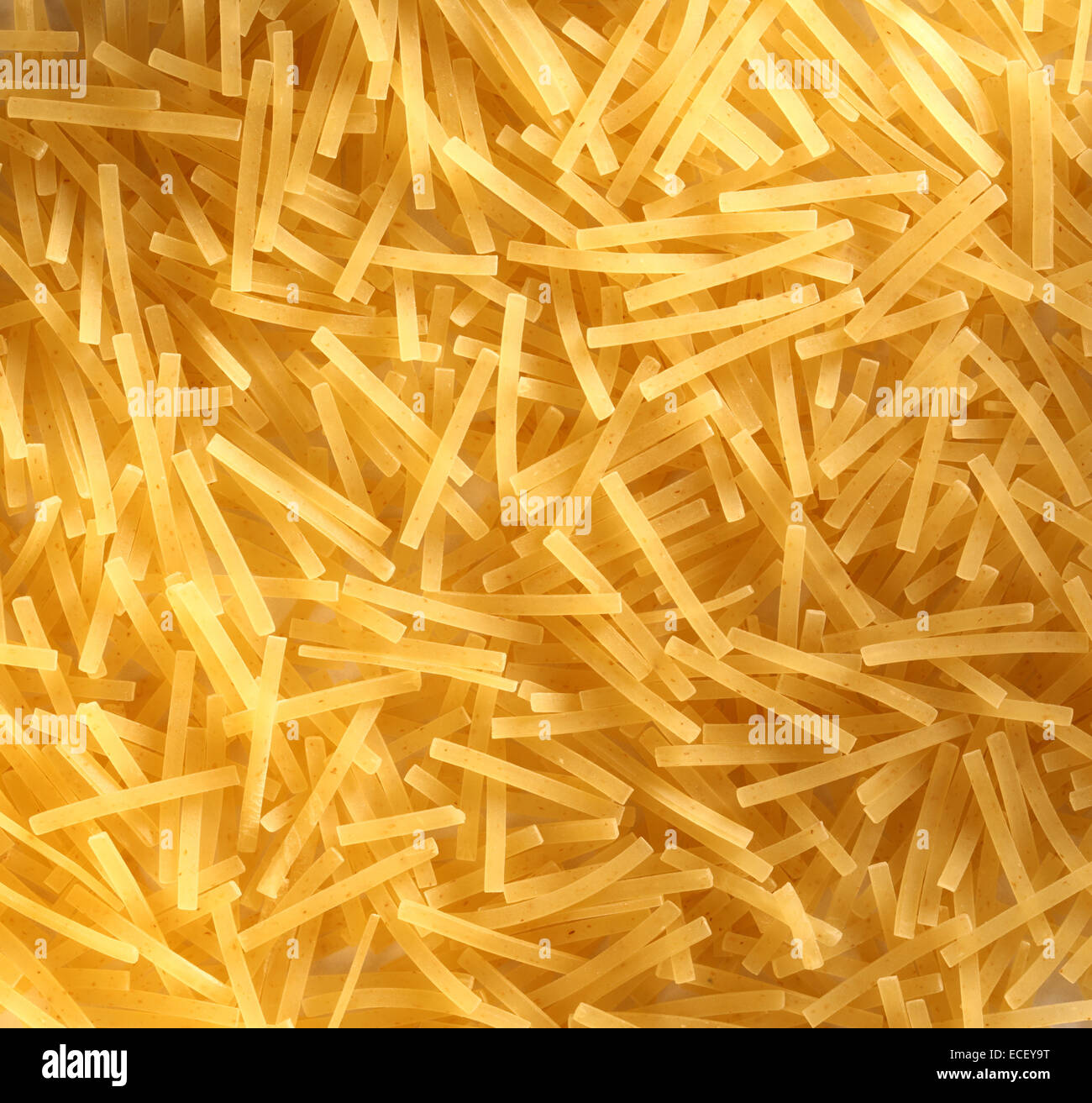 Short thin pasta tubes as background Stock Photo
