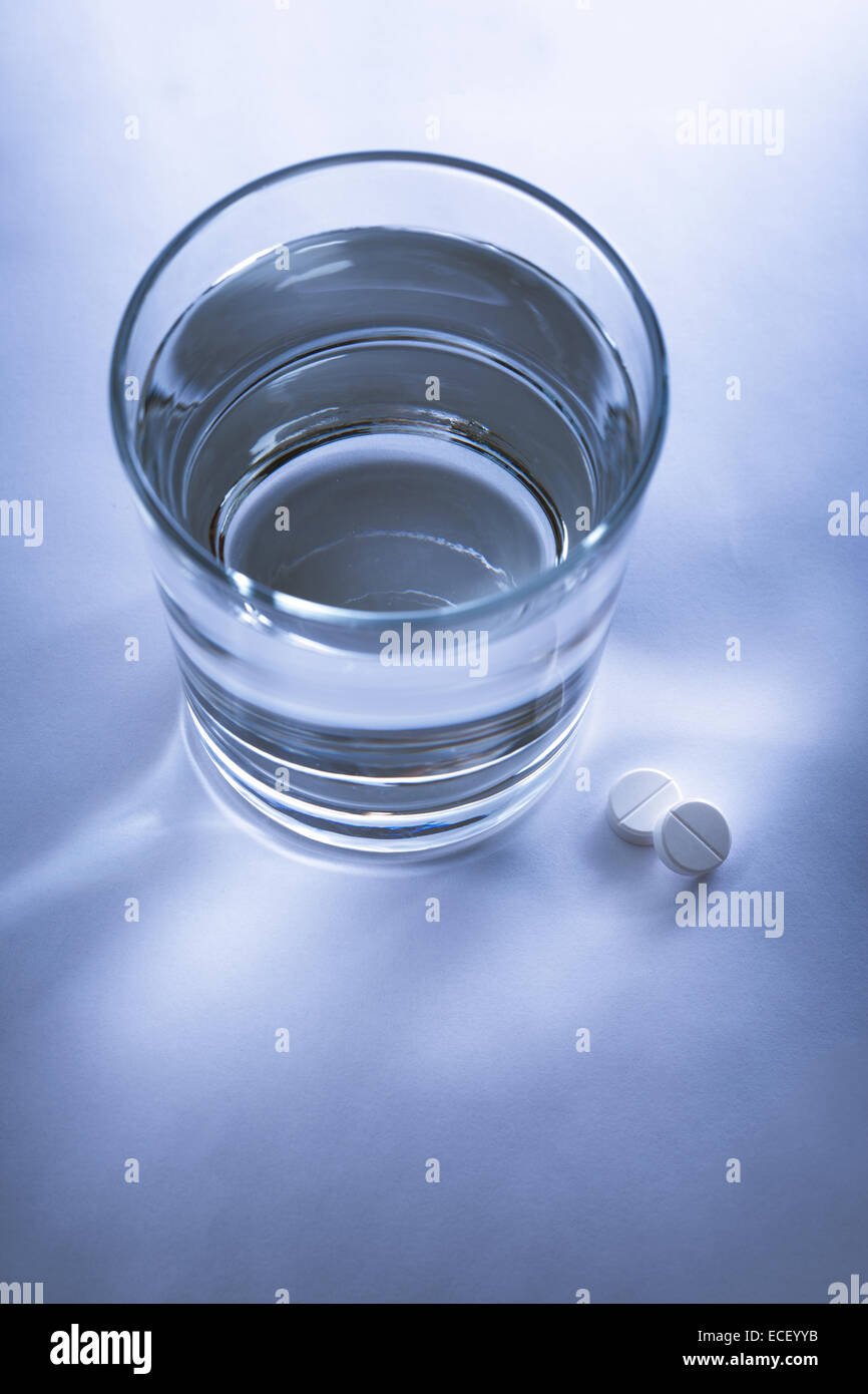 Glass of water and pills in blue toning Stock Photo