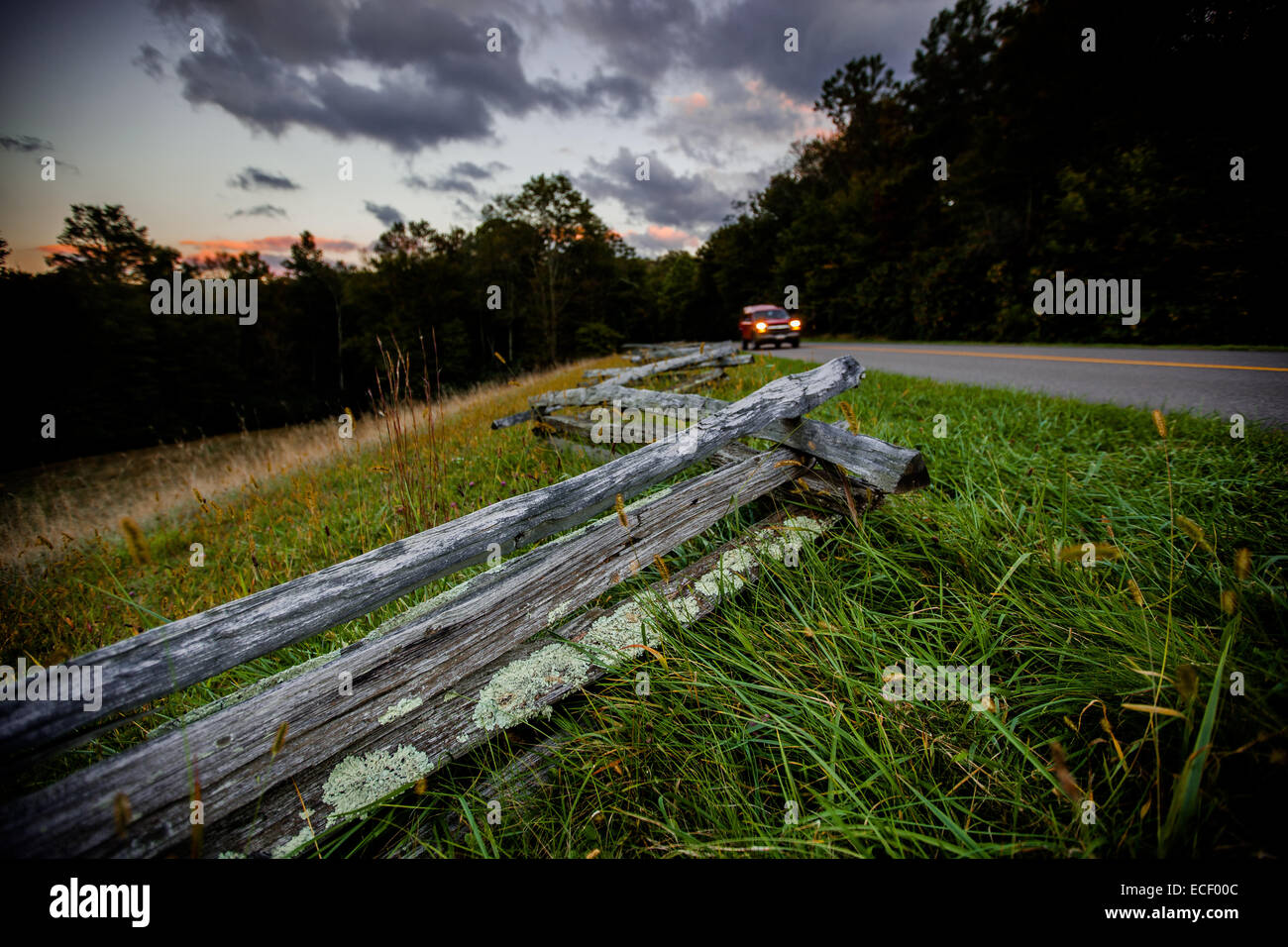 A car drives past the fences across from Price Lake at dusk at Julian Price Memorial Park in the Blue Ridge Parkway Stock Photo