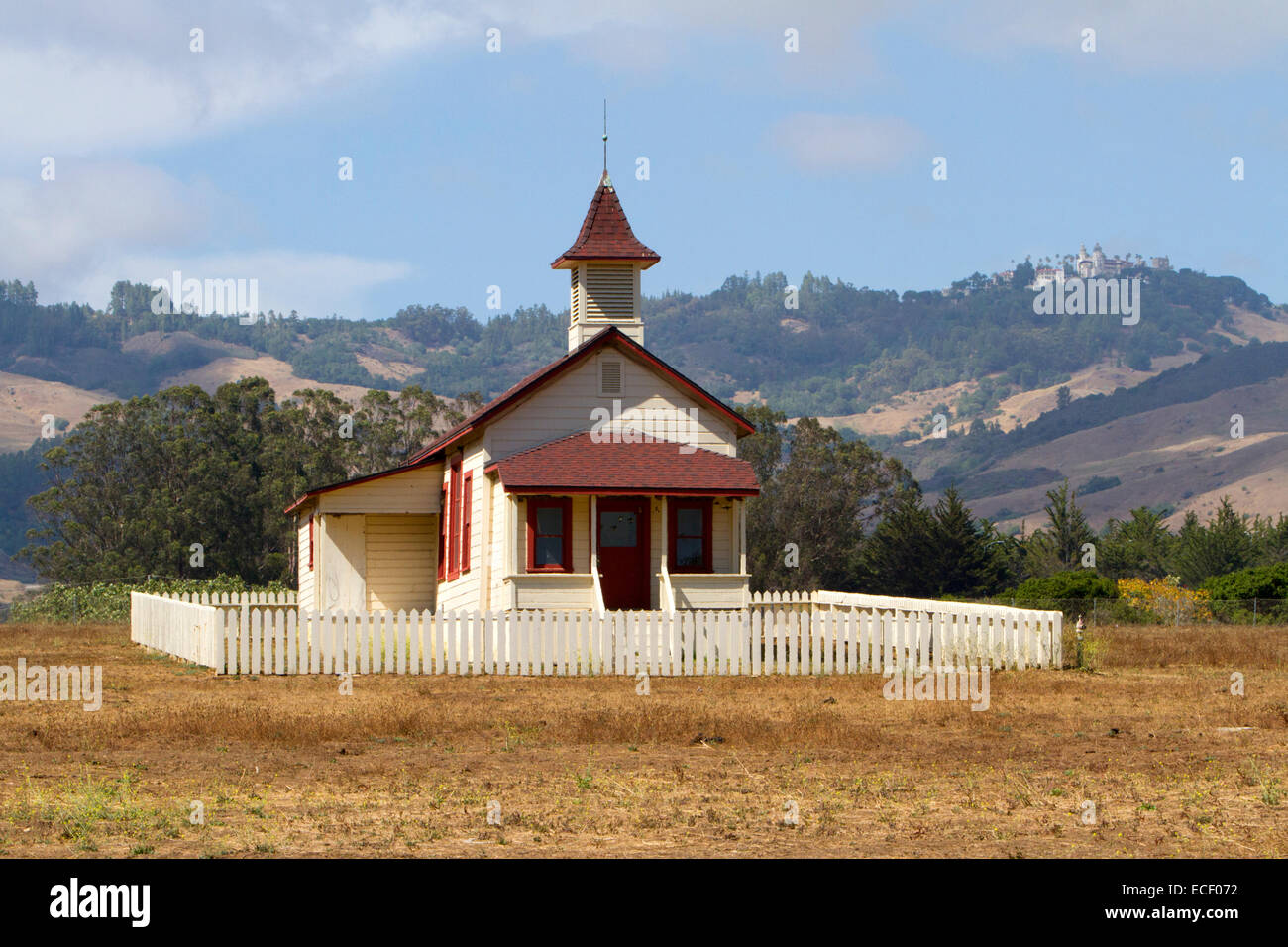 The Old School House with Hearst Castle on hills in background at San Simeon, California, USA in July Stock Photo